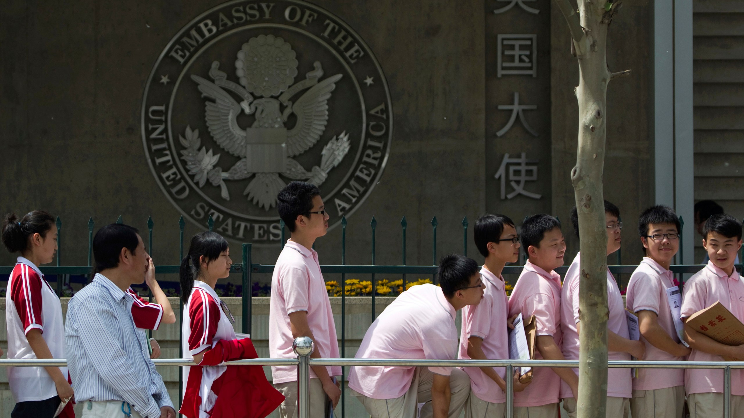 FILE - Chinese students wait outside the U.S. Embassy for their visa application interviews, in Beijing on May 2, 2012. (AP Photo/Alexander F. Yuan, File)