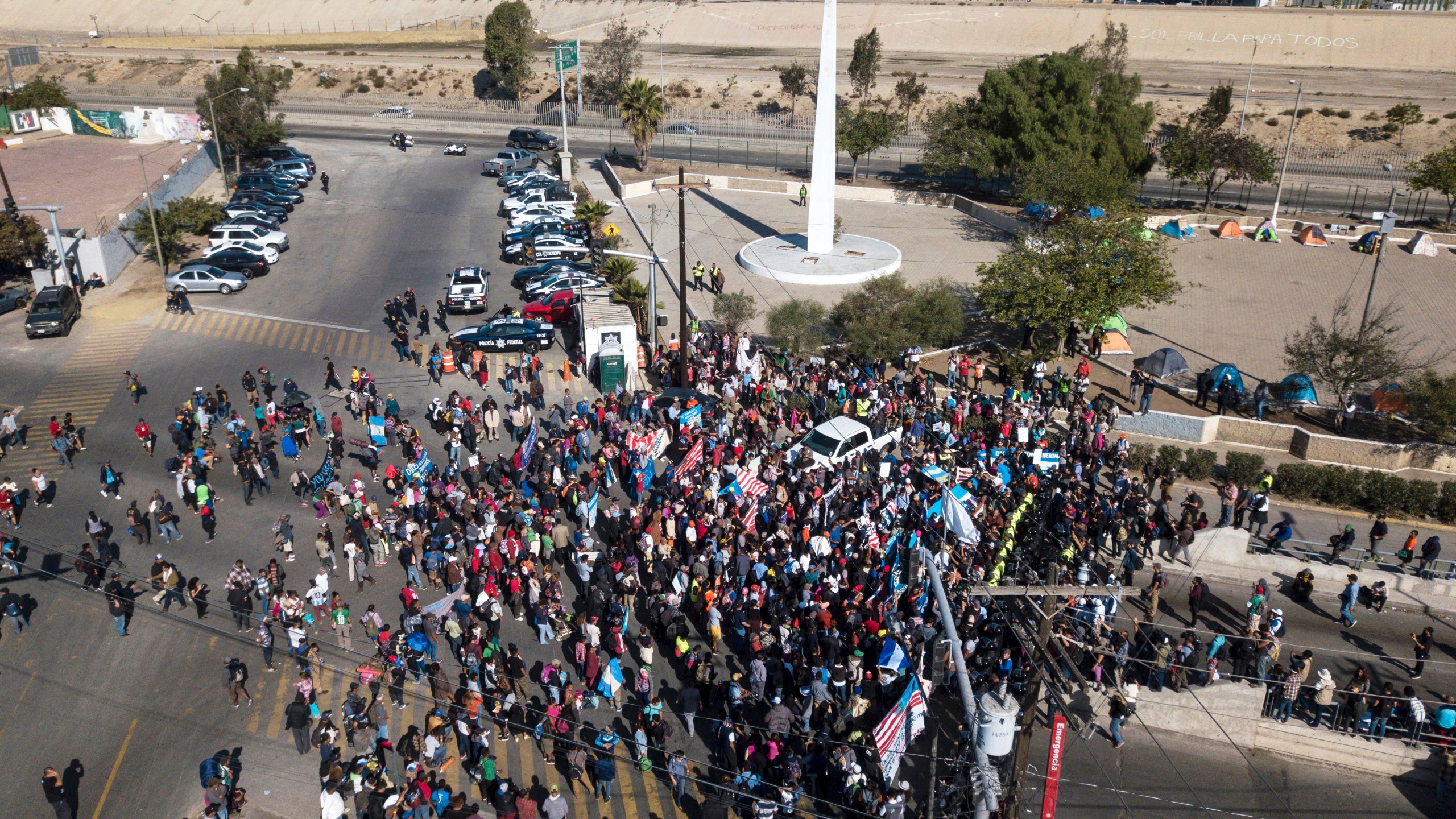 FILE - A group of migrants gather at the Chaparral border crossing in Tijuana, Mexico, Nov. 25, 2018, as the mayor of Tijuana declares a humanitarian crisis in his border city and says that he has asked the United Nations for aid to deal with the approximately 5,000 Central American migrants who have arrived in the city. (AP Photo/Rodrigo Abd, File)