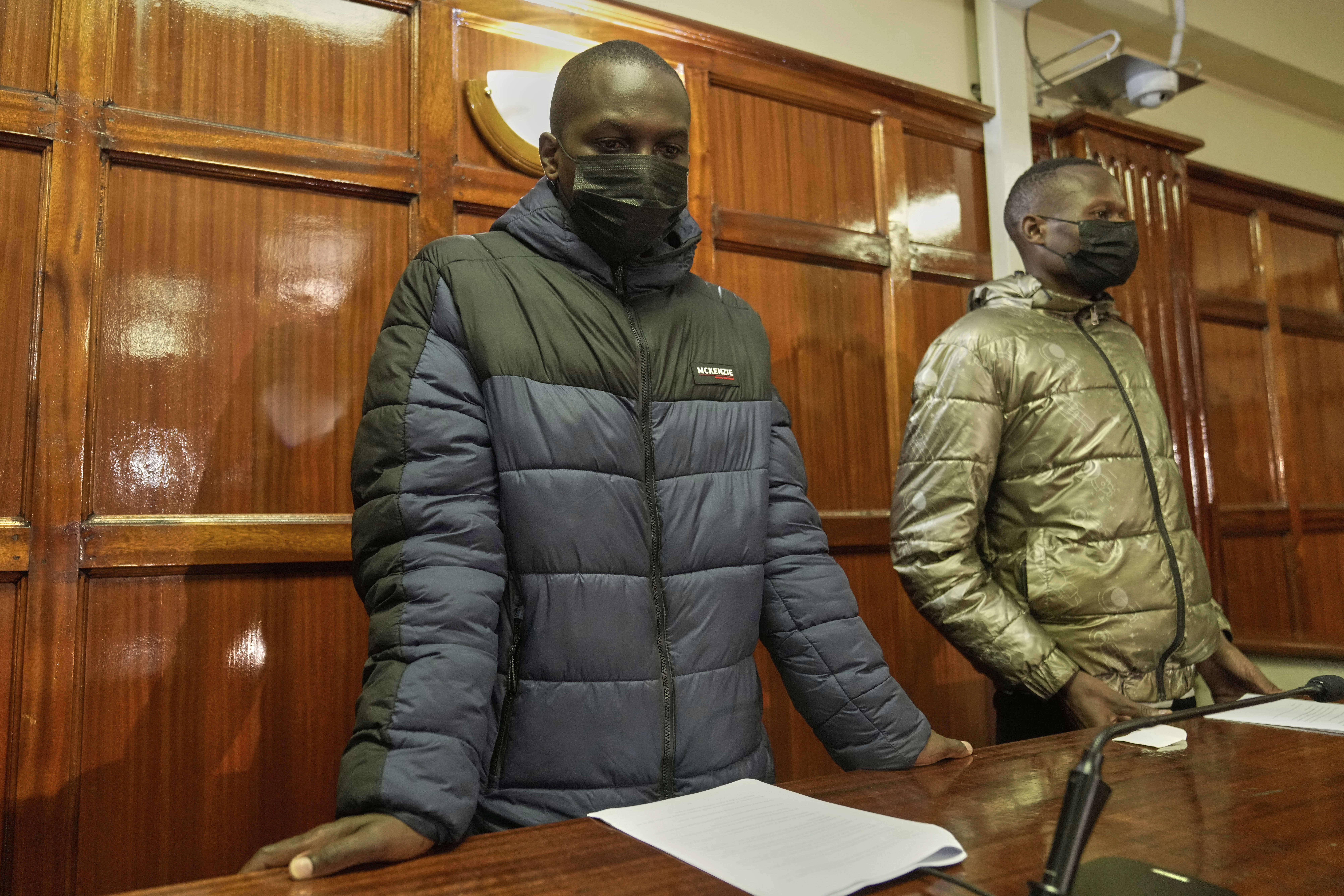 Kenya police officers Duncan Kiprono, left, and Klinzy Barasa, right, accused of assaulting and shooting hawker Boniface Kariuki during a protest, appear at the Milimani Law Courts in Nairobi, Kenya Thursday, June 19, 2025. (AP Photo/Brian Inganga)