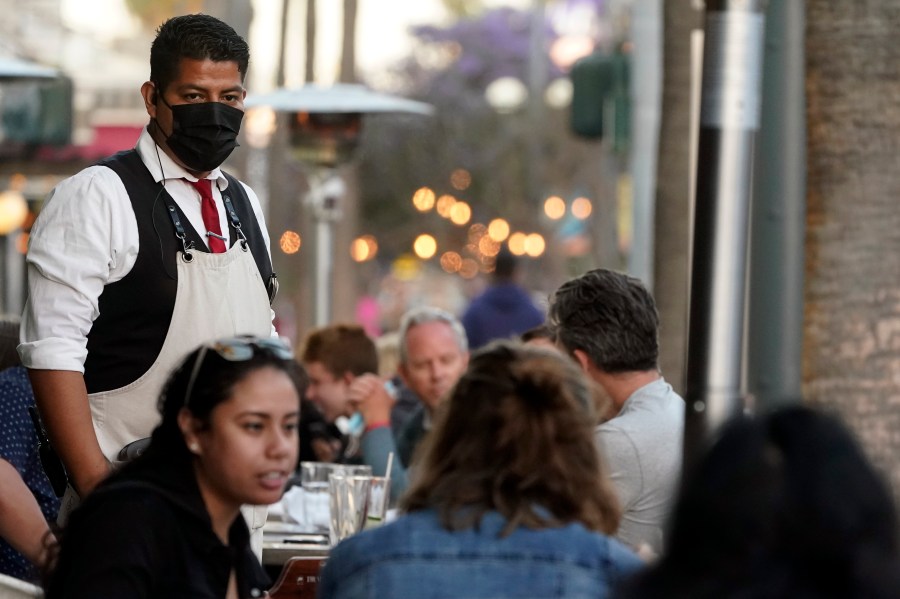 FILE - A server tends to customers in an outdoor dining area on The Promenade in Santa Monica, Calif., June 9, 2021. (AP Photo/Marcio Jose Sanchez, File)