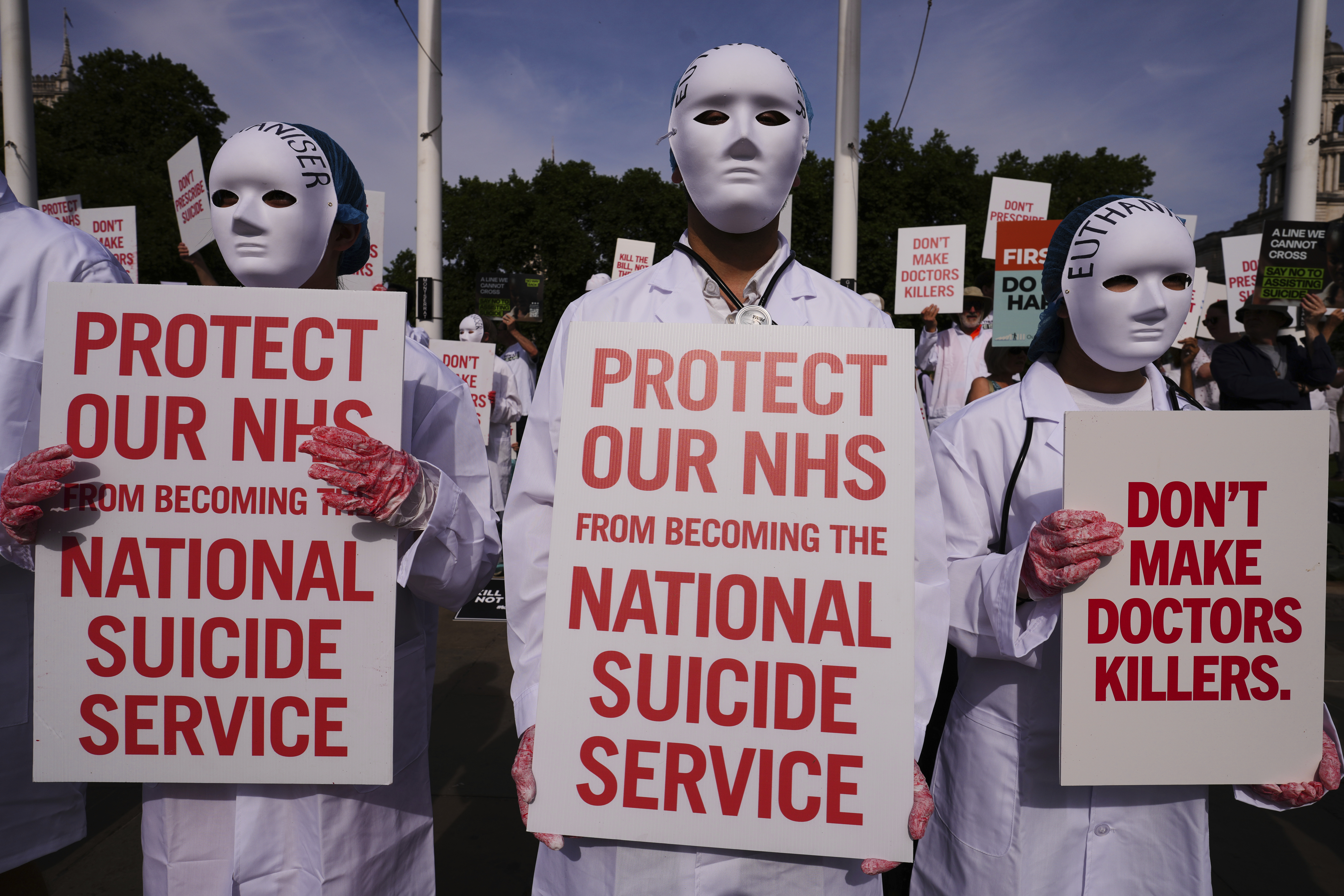 Demonstrators against assisted dying hold banners outside Parliament in London, Friday, June 20, 2025, as British lawmakers are set to vote Friday on whether to back a bill to help terminally ill adults end their lives in England and Wales. (AP Photo/Kirsty Wigglesworth)
