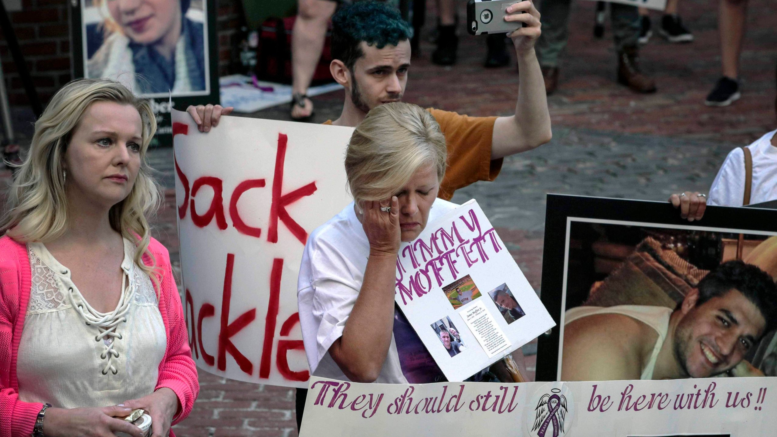 FILE - Protesters who have lost love ones to the opioid crisis protest outside a courthouse in Boston, Aug. 2, 2019, where a judge heard arguments in a lawsuit against Purdue Pharma. (AP Photo/Charles Krupa, File)