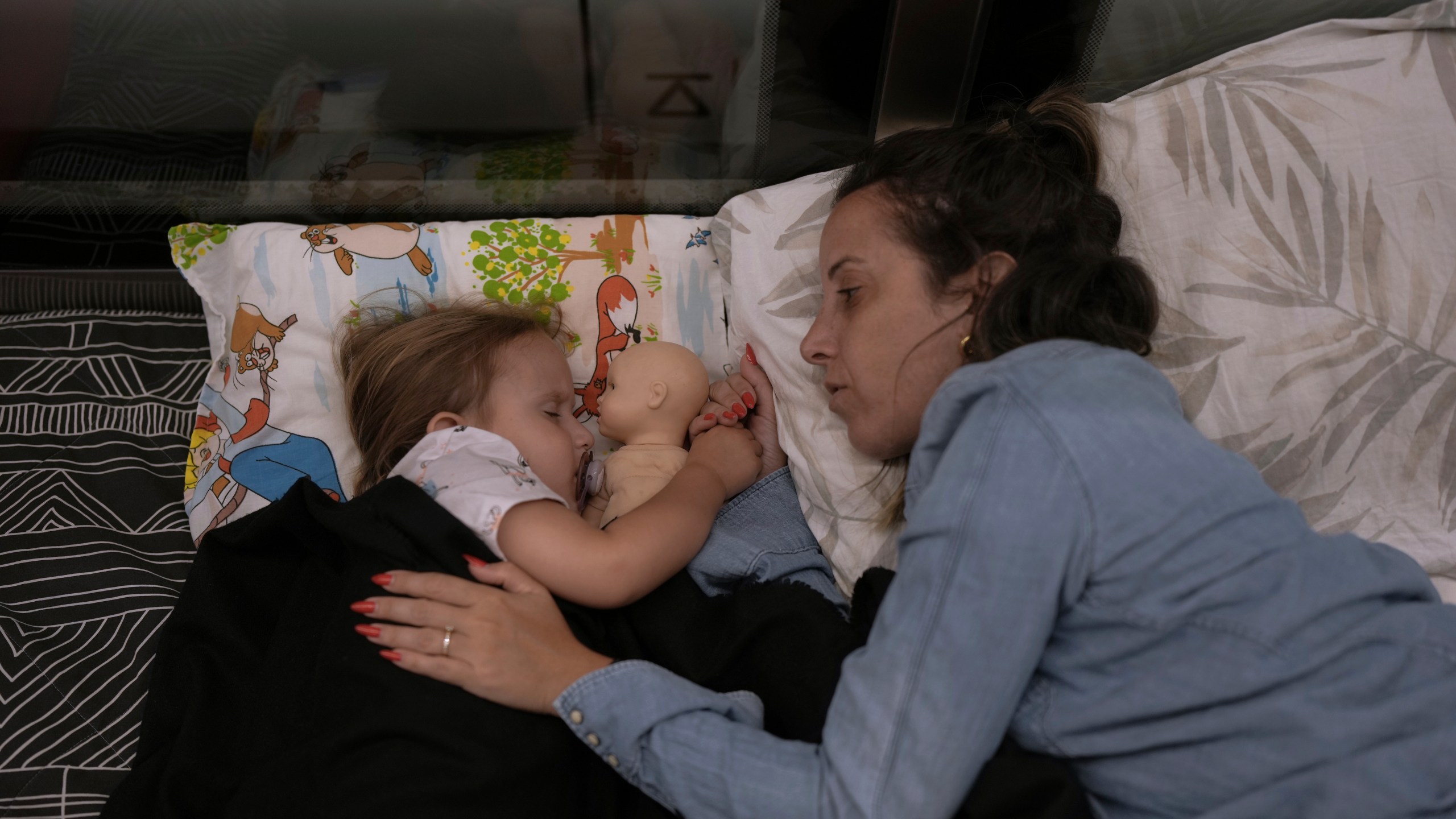 ADDS NAMES: Tehila Alush, and her daughter Ariel Asraf, 3, take shelter in an underground metro station as a precaution against possible Iran missile attacks, in Ramat Gan, near Tel Aviv, Israel, Tuesday, June 17, 2025. (AP Photo/Oded Balilty)