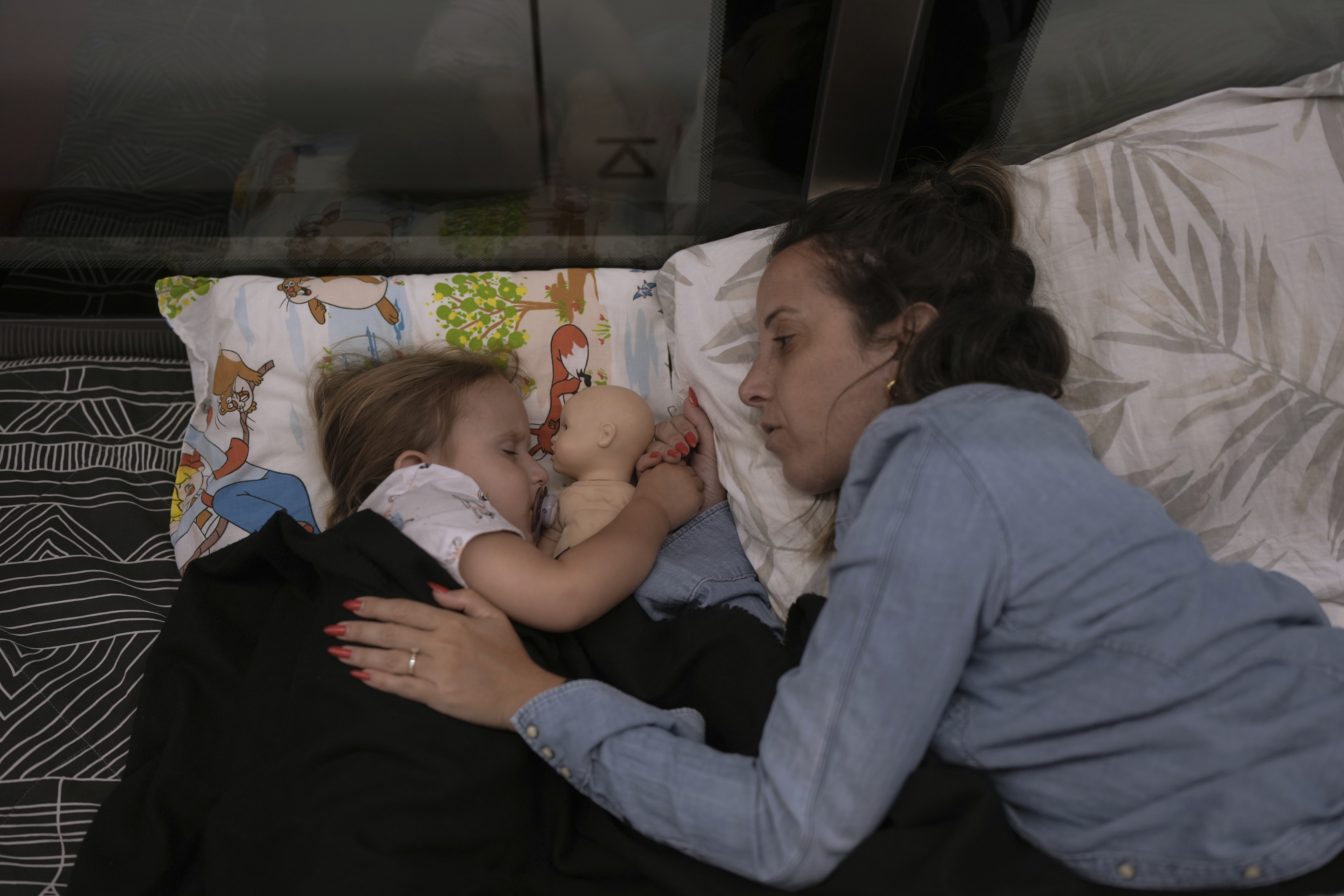 ADDS NAMES: Tehila Alush, and her daughter Ariel Asraf, 3, take shelter in an underground metro station as a precaution against possible Iran missile attacks, in Ramat Gan, near Tel Aviv, Israel, Tuesday, June 17, 2025. (AP Photo/Oded Balilty)