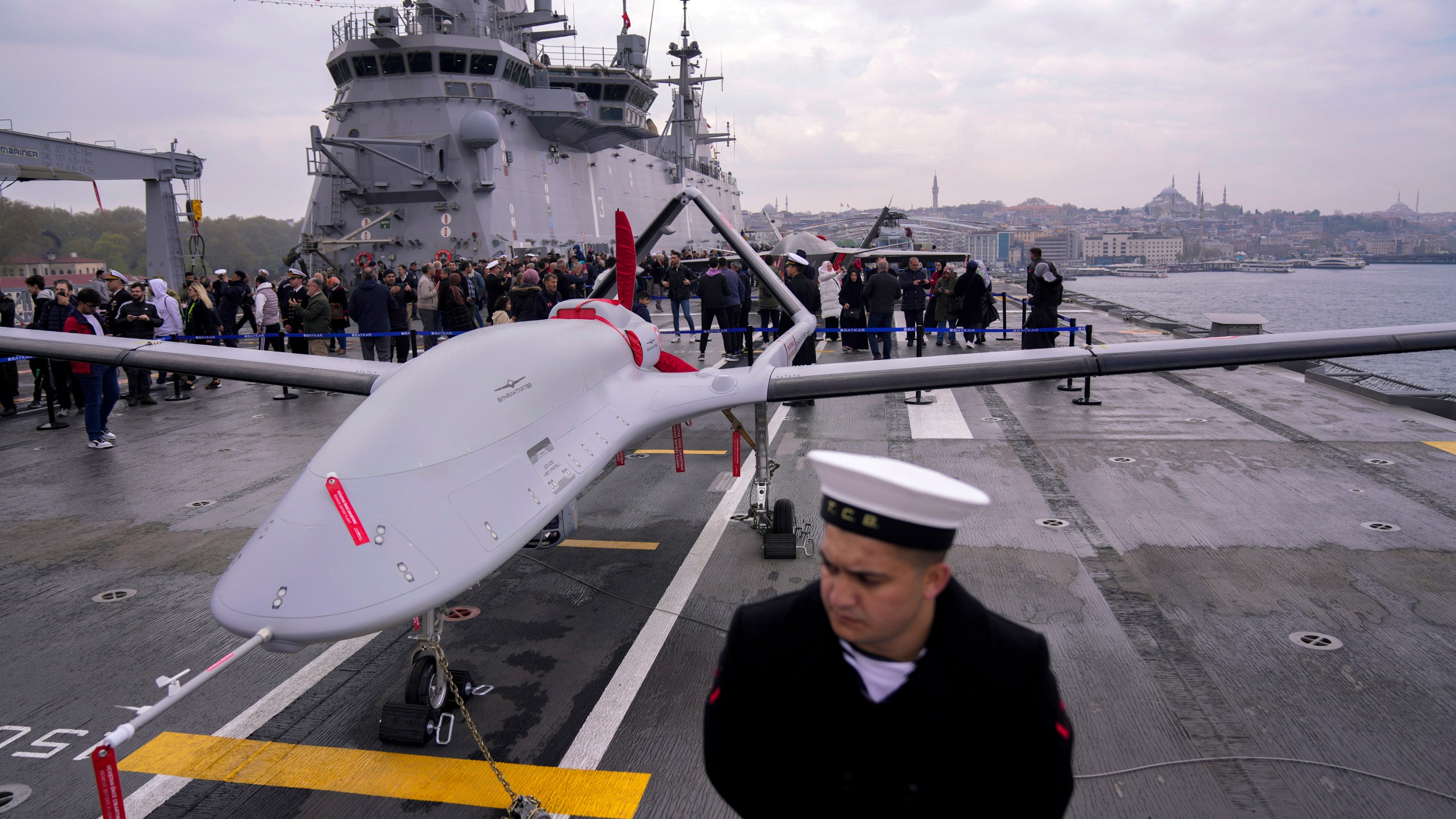 FILE - A navy soldier stands next to an unmanned combat aerial vehicle (UCAV) Bayraktar TB3 on board the Turkish amphibious assault ship TCG Anadolu L400, anchored in Istanbul, Turkey, Thursday, April 20, 2023. (AP Photo/Francisco Seco, File)