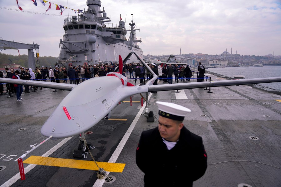 FILE - A navy soldier stands next to an unmanned combat aerial vehicle (UCAV) Bayraktar TB3 on board the Turkish amphibious assault ship TCG Anadolu L400, anchored in Istanbul, Turkey, Thursday, April 20, 2023. (AP Photo/Francisco Seco, File)