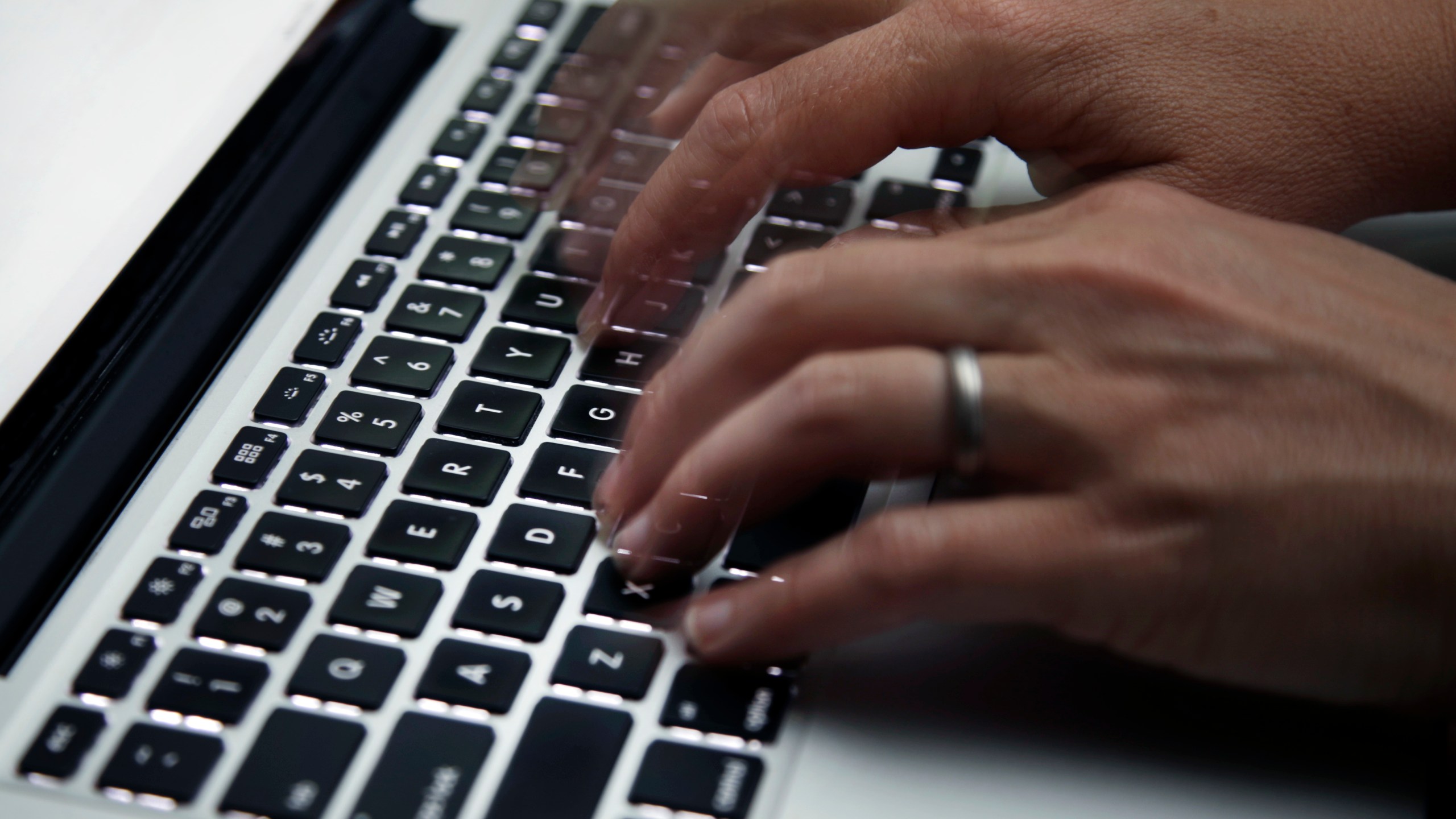 FILE - This June 19, 2017 file photo shows a person working on a laptop in North Andover, Mass. (AP Photo/Elise Amendola, File)