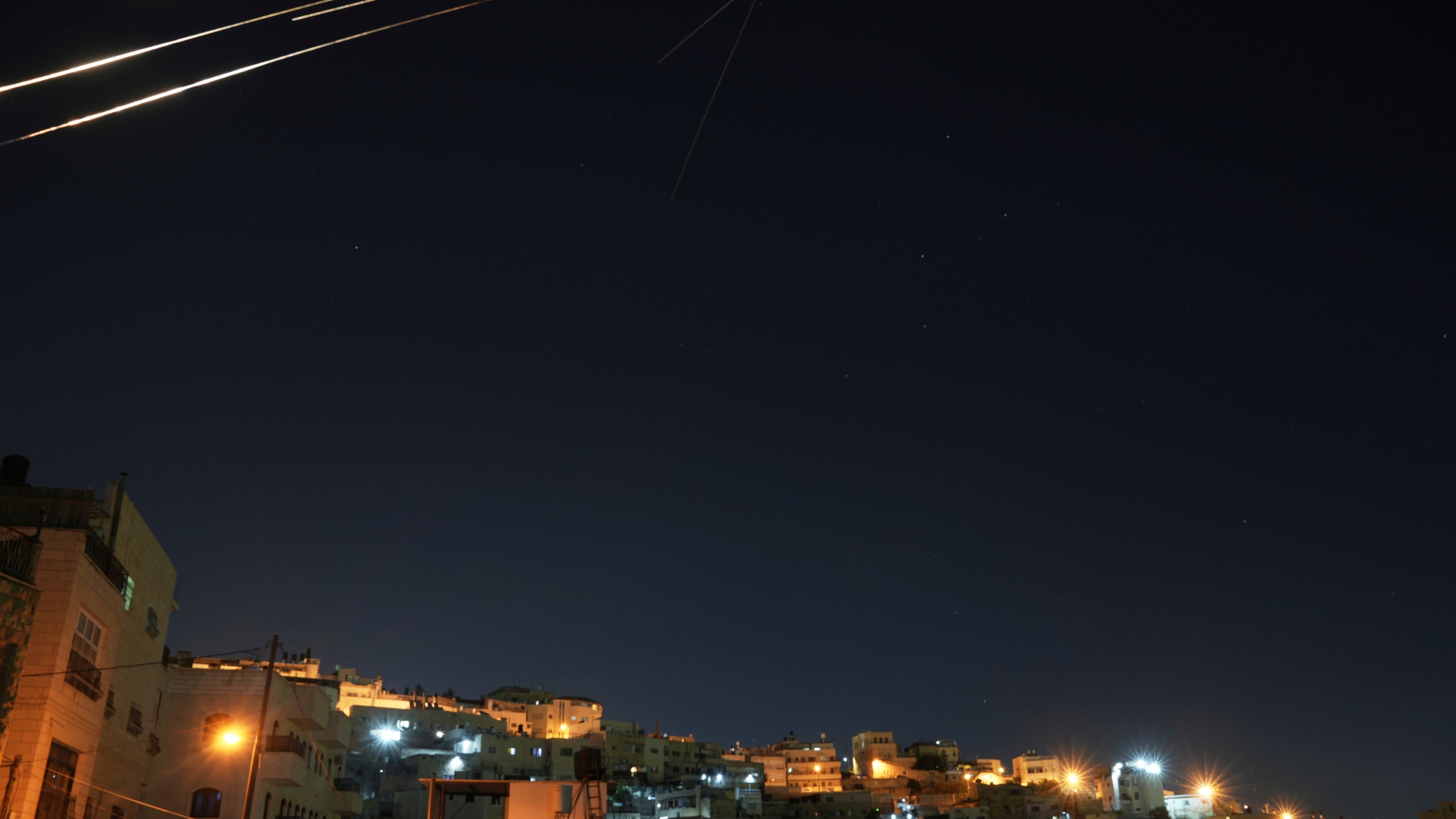 Missiles seen from Jerusalem illuminate the night sky during an Iranian missile attack, early Sunday, June 15, 2025. (AP Photo/Mahmoud Illean)