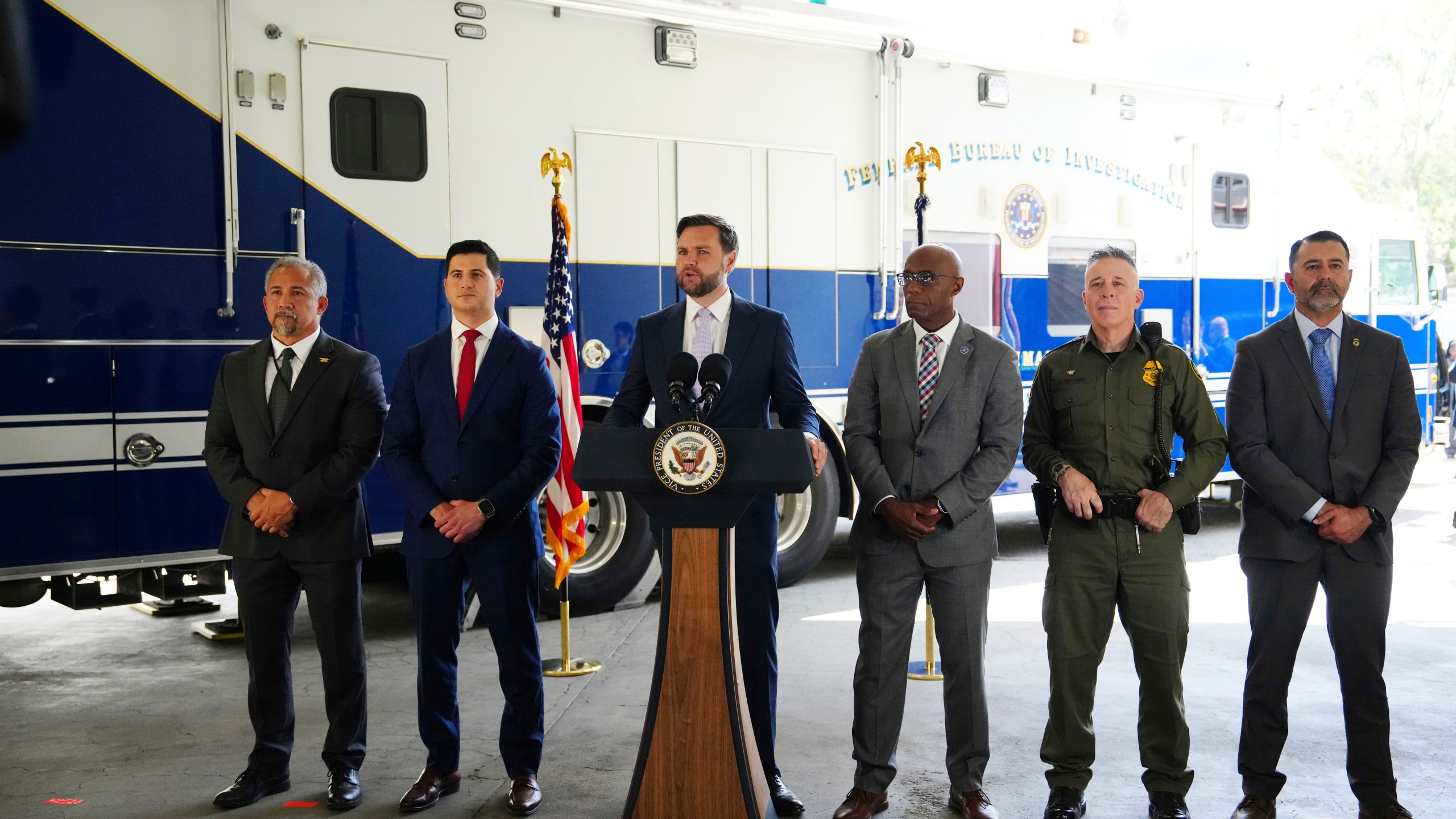 Vice President JD Vance, center, speaks next to officials including, from left to right, HUD Regional Administrator William Spencer, United States Attorney for the Central District of California Bill Essayli, FBI Los Angeles Assistant Director Akil Davis, US Border Patrol Sector Chief Gregory Bovino and ICE Field Office Director Ernie Santacruz at the Wilshire Federal Building Friday, June 20, 2025, in Los Angeles. (AP Photo/Jae C. Hong)