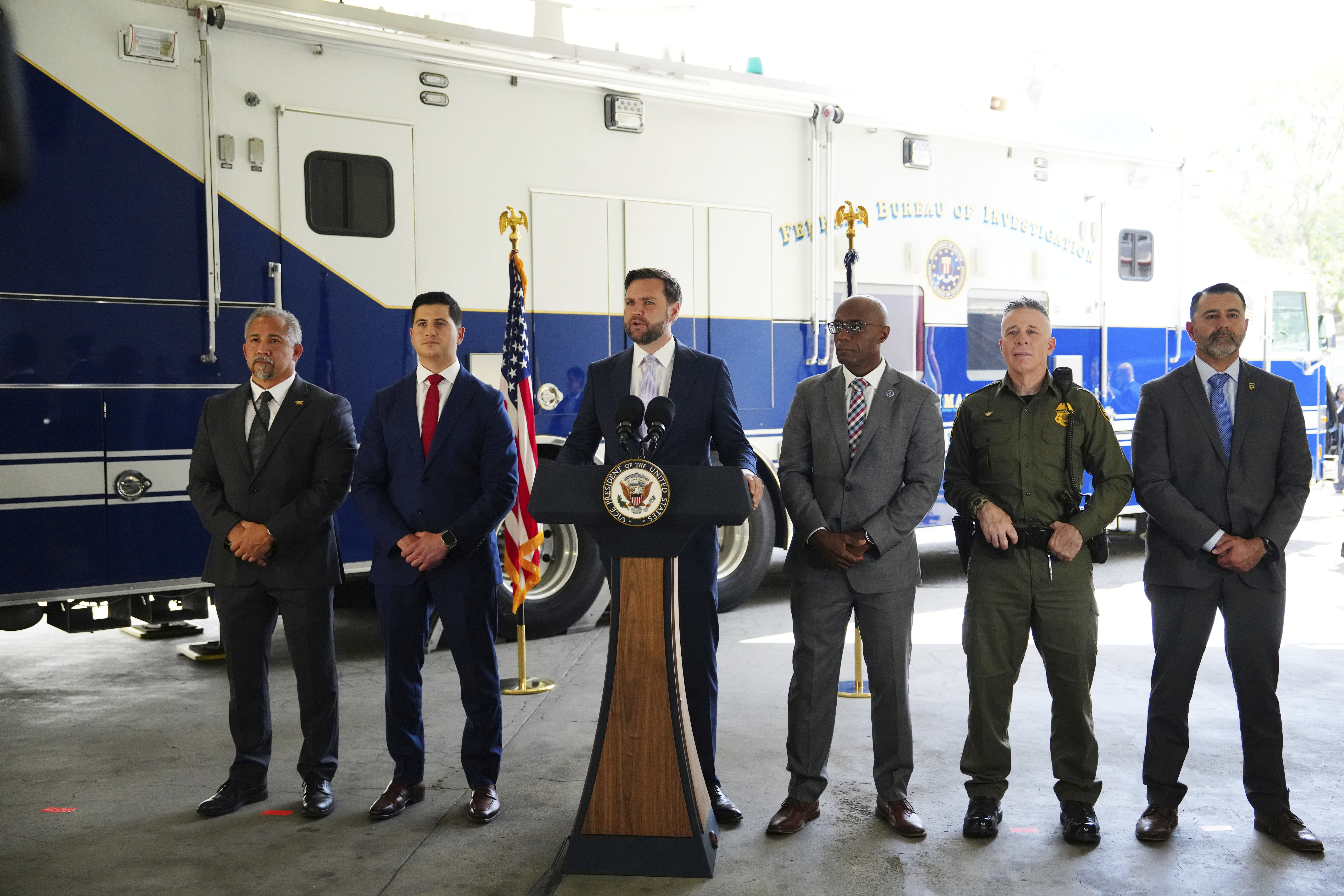 Vice President JD Vance, center, speaks next to officials including, from left to right, HUD Regional Administrator William Spencer, United States Attorney for the Central District of California Bill Essayli, FBI Los Angeles Assistant Director Akil Davis, US Border Patrol Sector Chief Gregory Bovino and ICE Field Office Director Ernie Santacruz at the Wilshire Federal Building Friday, June 20, 2025, in Los Angeles. (AP Photo/Jae C. Hong)