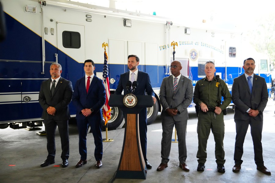 Vice President JD Vance, center, speaks next to officials including, from left to right, HUD Regional Administrator William Spencer, United States Attorney for the Central District of California Bill Essayli, FBI Los Angeles Assistant Director Akil Davis, US Border Patrol Sector Chief Gregory Bovino and ICE Field Office Director Ernie Santacruz at the Wilshire Federal Building Friday, June 20, 2025, in Los Angeles. (AP Photo/Jae C. Hong)