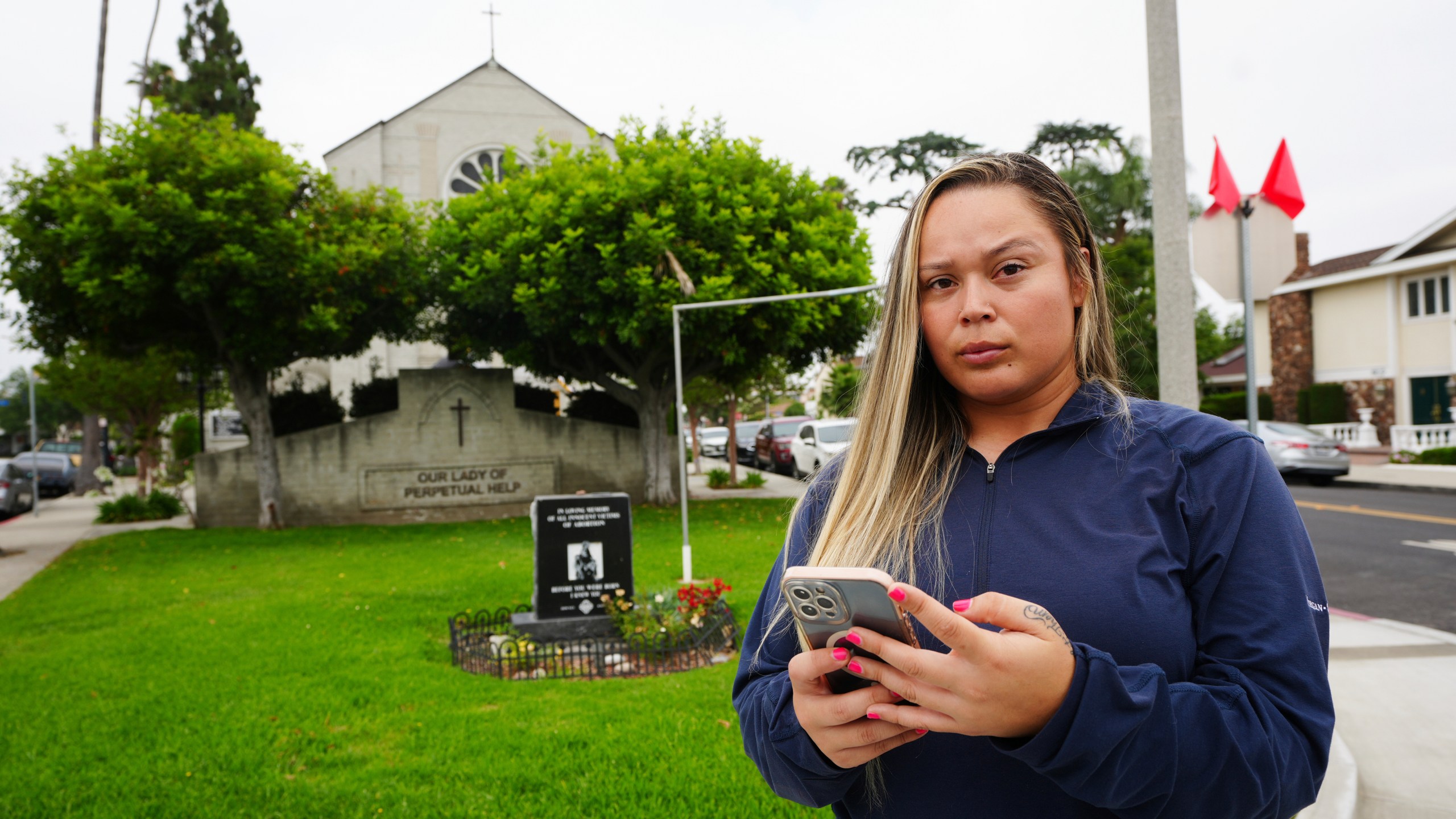Melyssa Rivas poses for a photo at a location where she witnessed masked federal agents detaining a person earlier this month outside Our Lady of Perpetual Help Catholic Church in Downey, Calif., on Friday, June 20, 2025. (AP Photo/Damian Dovarganes)