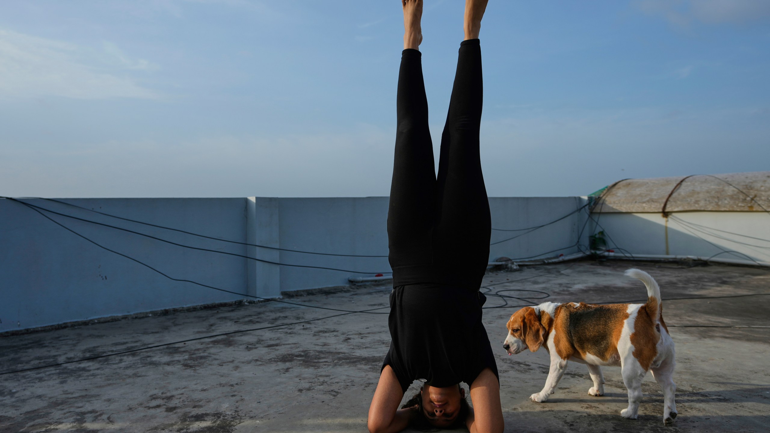A girl performs yoga on the roof of an apartment on International Day of Yoga in Hyderabad, India, Saturday, June 21, 2025. (AP Photo/Mahesh Kumar A.)