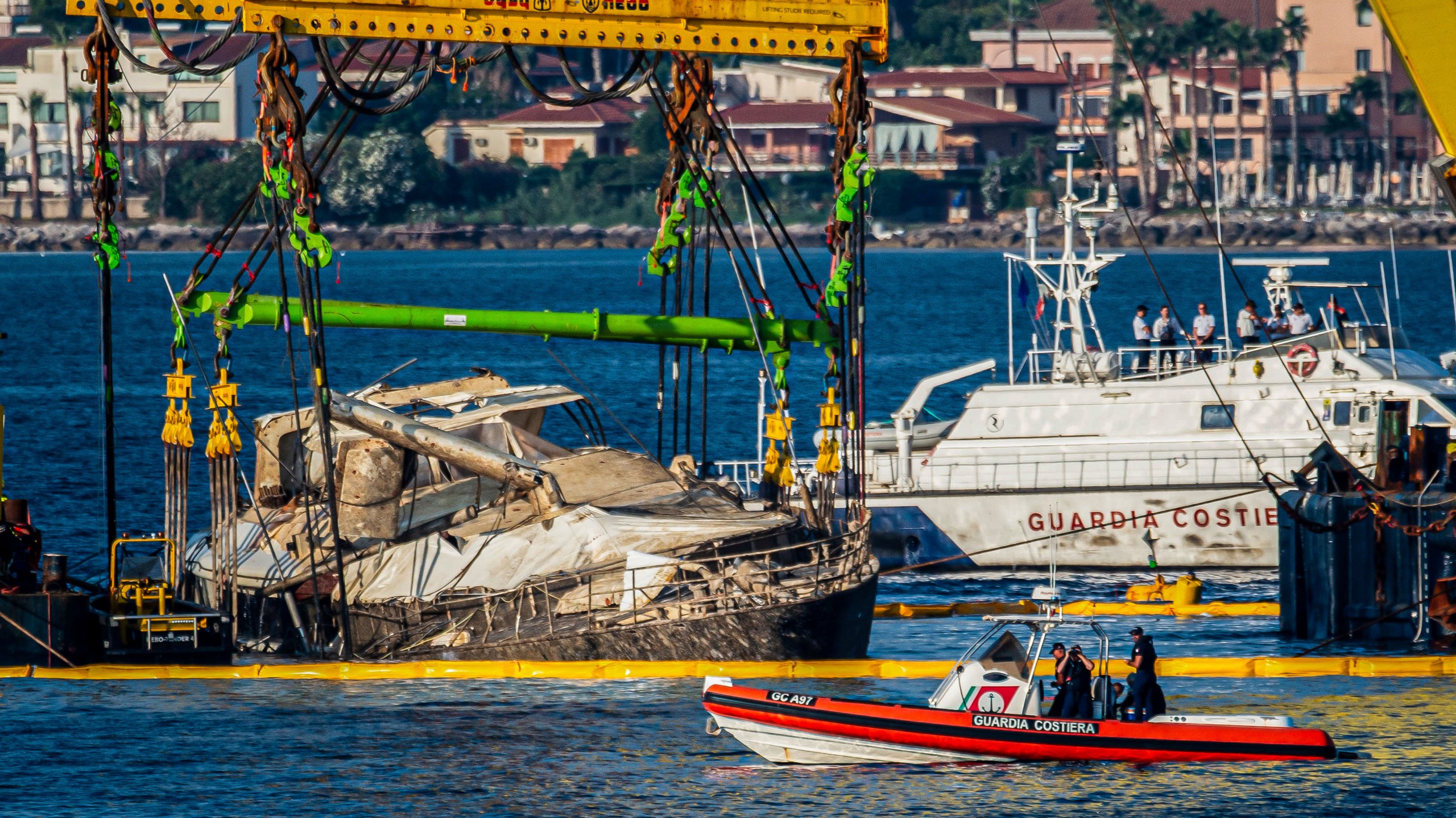 The hull of the superyacht Bayesian, which sank near Palermo, Sicily, on August 19, 2024, is lifted by cranes during salvage operations off the village of Porticello Saturday, June 21, 2025. (AP Photo/Salvatore Cavalli)