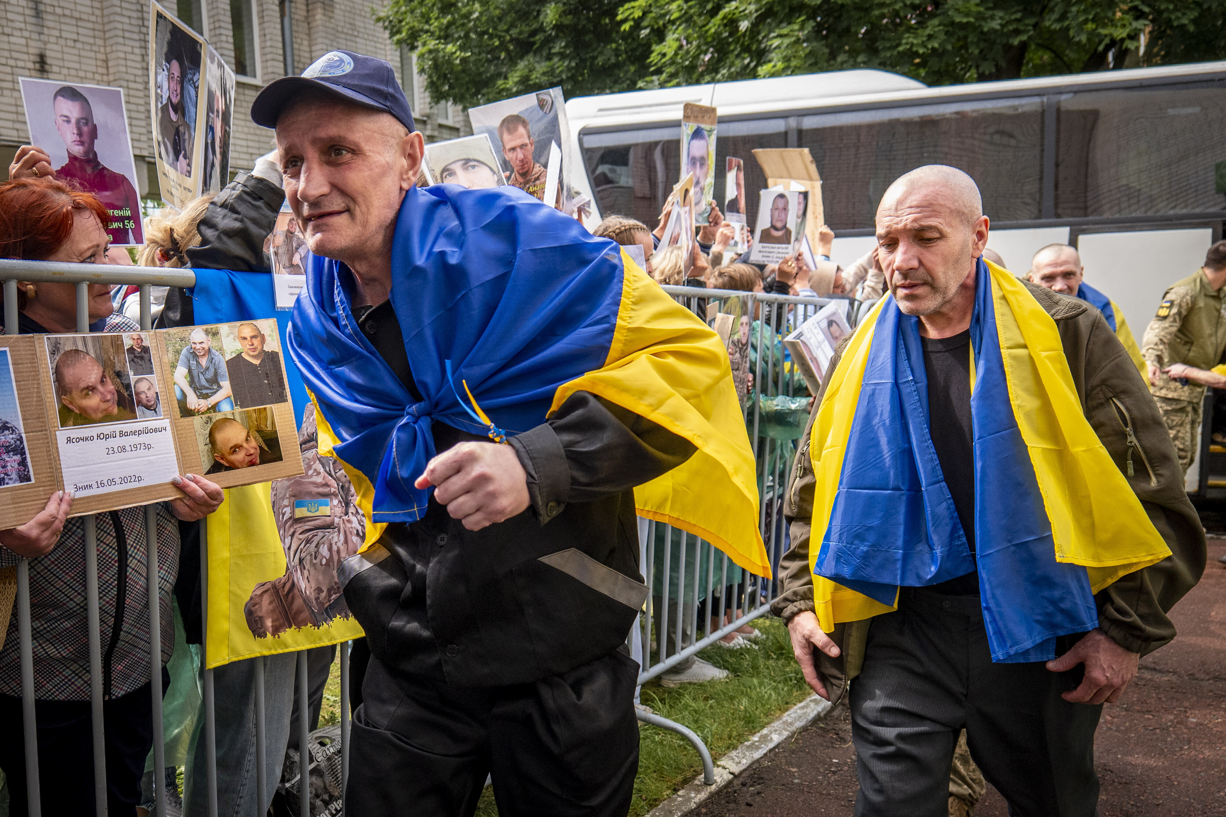 Freed Ukrainian soldiers arriving after a POW exchange with Russia walk past Ukrainians holding photos of their missing relatives in the Chernyhiv region, Ukraine, Friday, June 20, 2025. (AP Photo/Dan Bashakov)