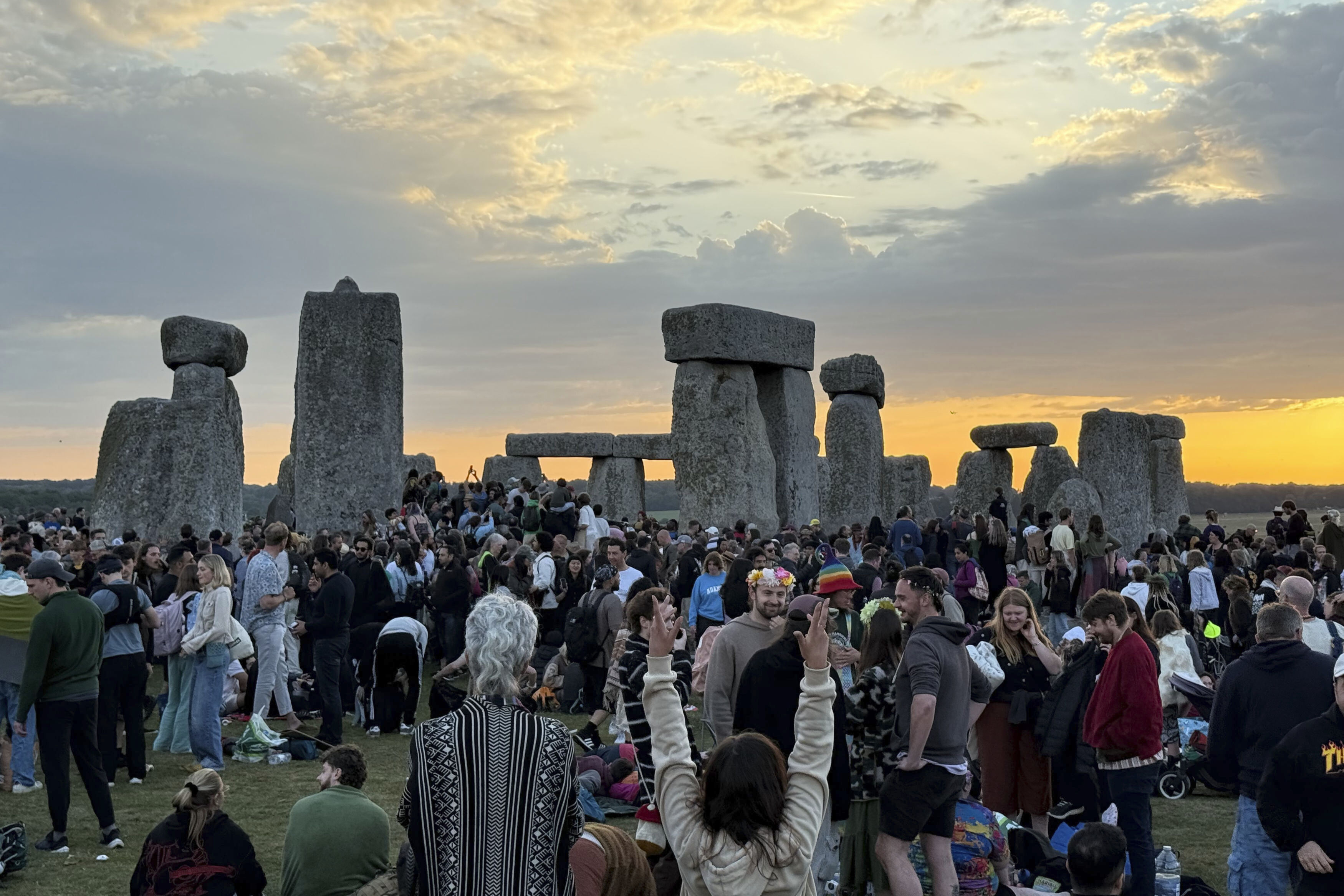 People gather at Stonehenge, England, during sunrise on the summer solstice, the longest day of the year, Saturday, June 21, 2025. (Zhanna Manukyan/PA via AP)