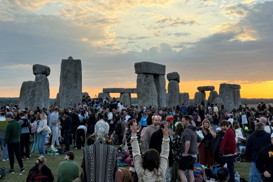 People gather at Stonehenge, England, during sunrise on the summer solstice, the longest day of the year, Saturday, June 21, 2025. (Zhanna Manukyan/PA via AP)