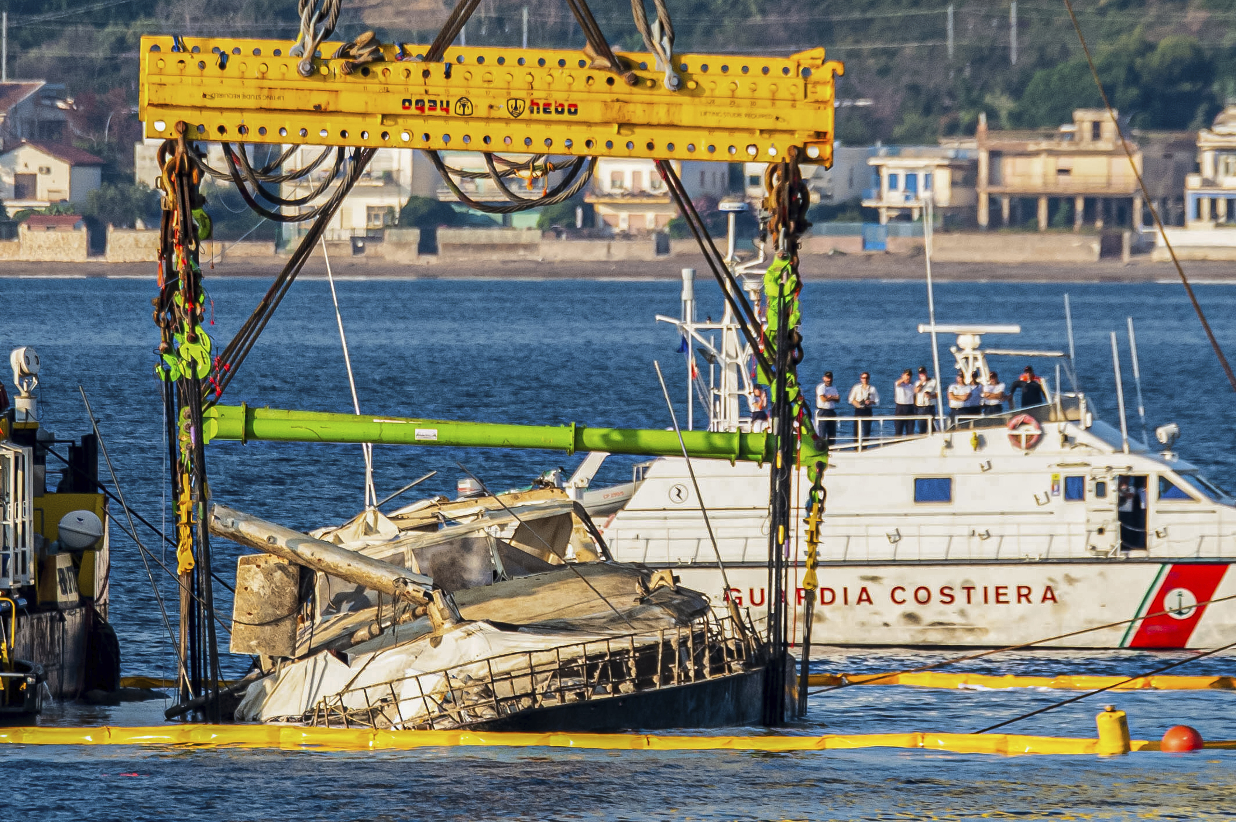 The hull of the superyacht Bayesian, which sank near Palermo, Sicily, on August 19, 2024, is lifted by cranes during salvage operations off the village of Porticciolo Saturday, June 21, 2025. (AP Photo/Salvatore Cavalli)