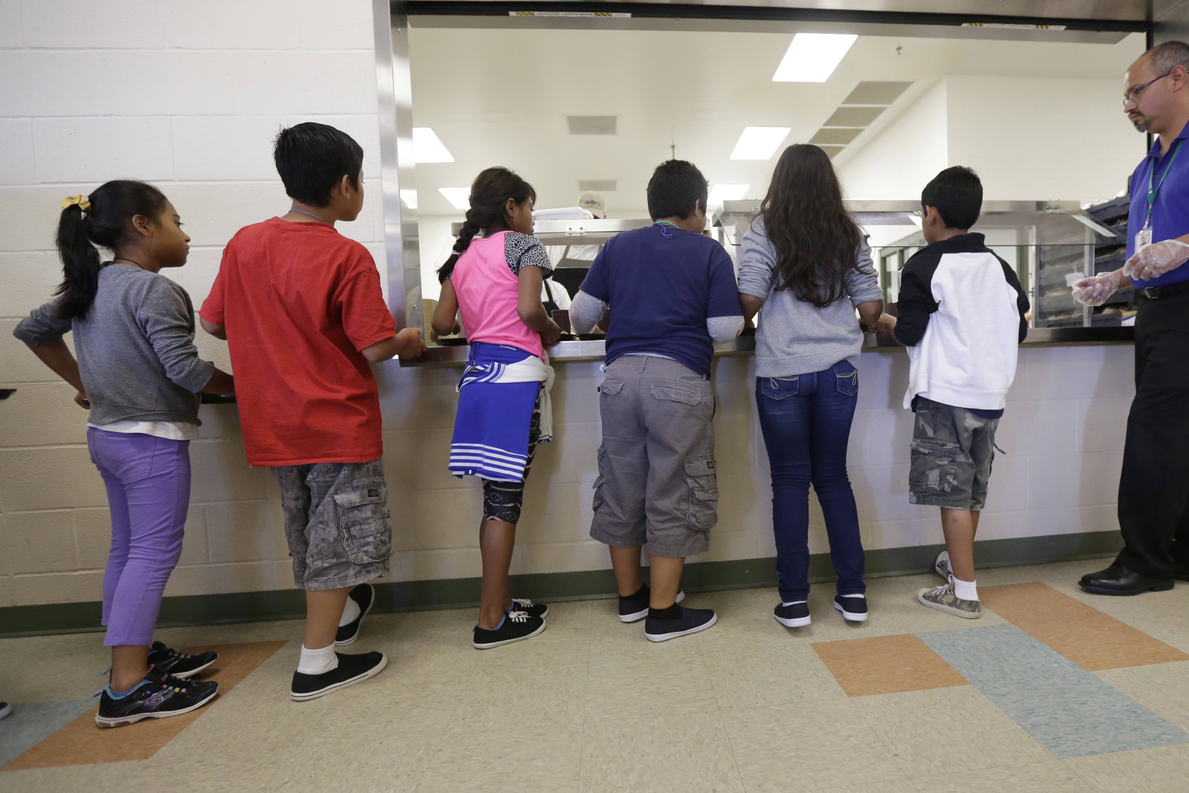 FILE - Detained immigrant children line up in the cafeteria at the Karnes County Residential Center, a detention center for immigrant families, in Karnes City, Texas on Sept. 10, 2014. (AP Photo/Eric Gay, File)