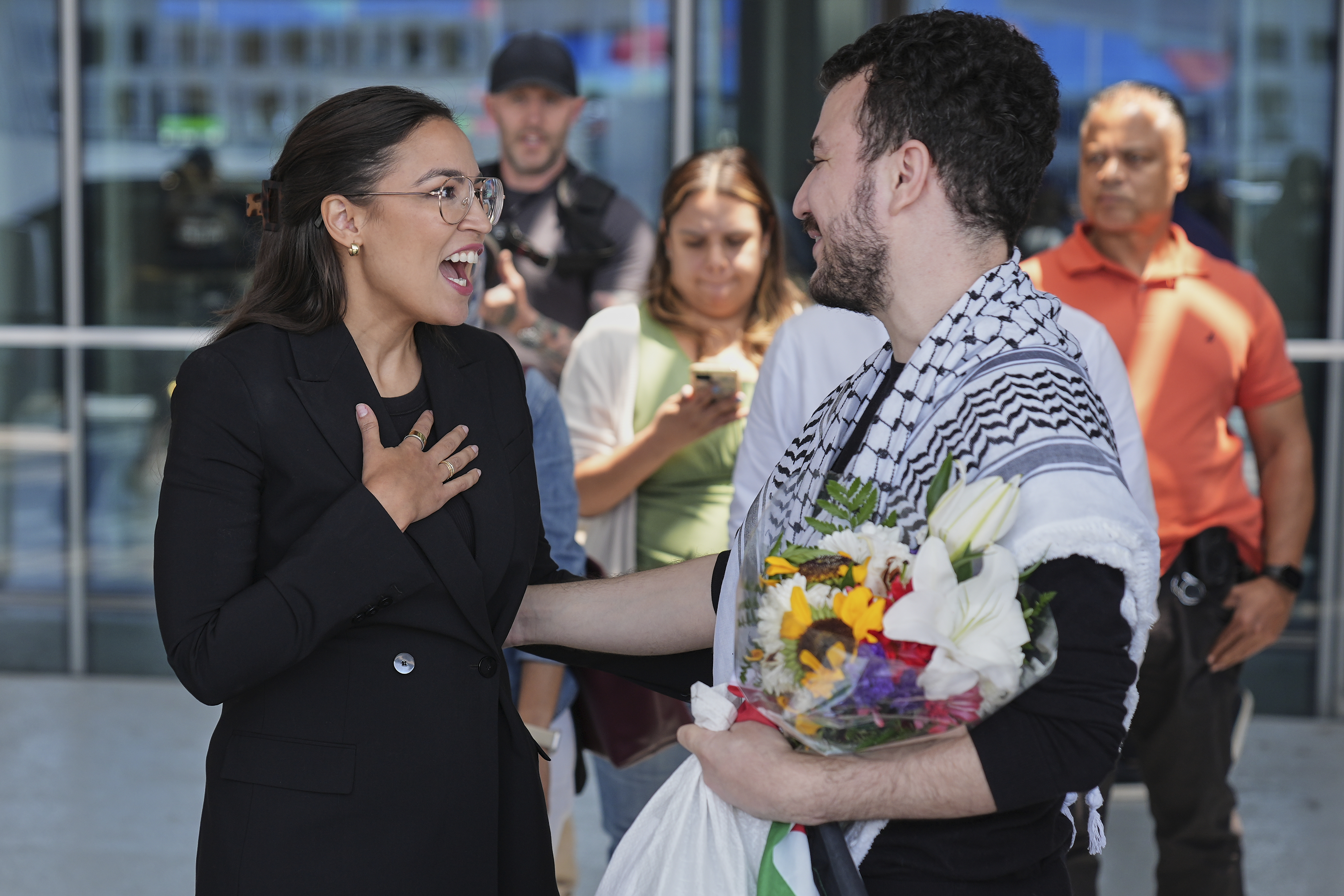 Mahmoud Khalil, right, speaks to Rep. Alexandria Ocasio-Cortez, D-N.Y., after arriving at Newark International Airport, Saturday, June 21, 2025, in Newark, N.J. (AP Photo/Seth Wenig)