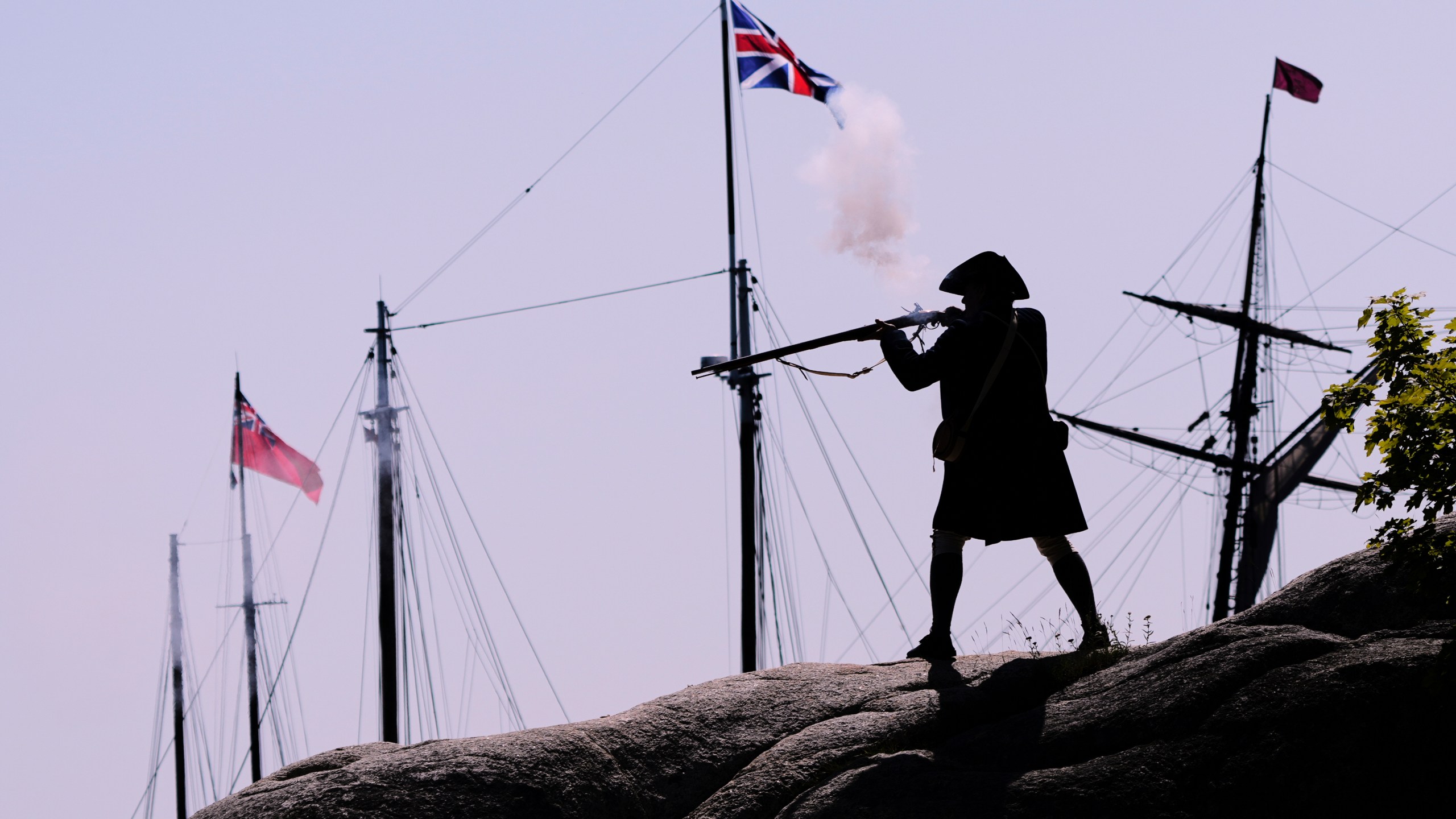 A Colonial soldier fires on the British during a reenactment in celebration of the 250th anniversary of the Battle of Bunker Hill, Saturday, June 21, 2025, in Gloucester, Mass. (AP Photo/Charles Krupa)