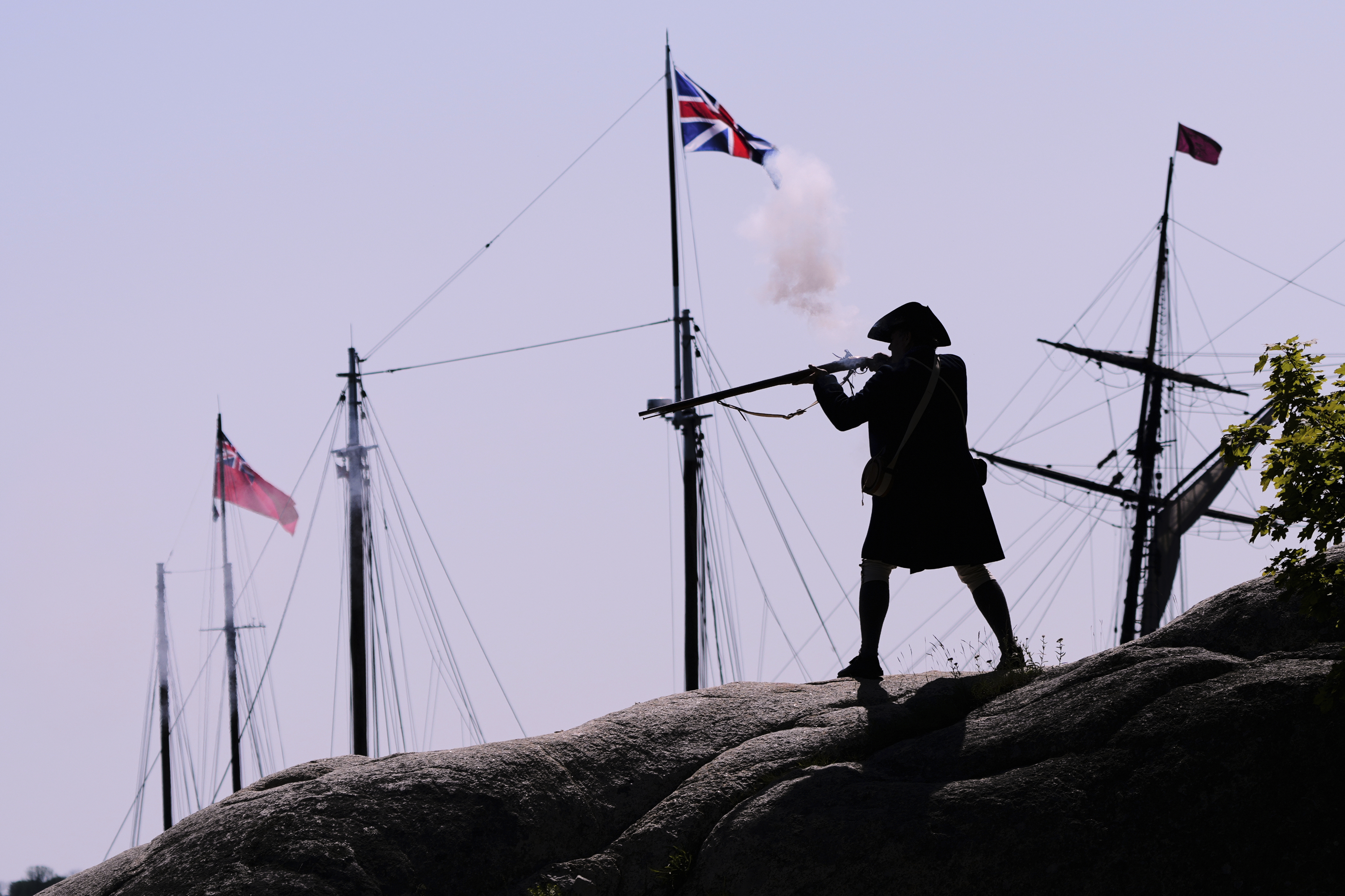A Colonial soldier fires on the British during a reenactment in celebration of the 250th anniversary of the Battle of Bunker Hill, Saturday, June 21, 2025, in Gloucester, Mass. (AP Photo/Charles Krupa)