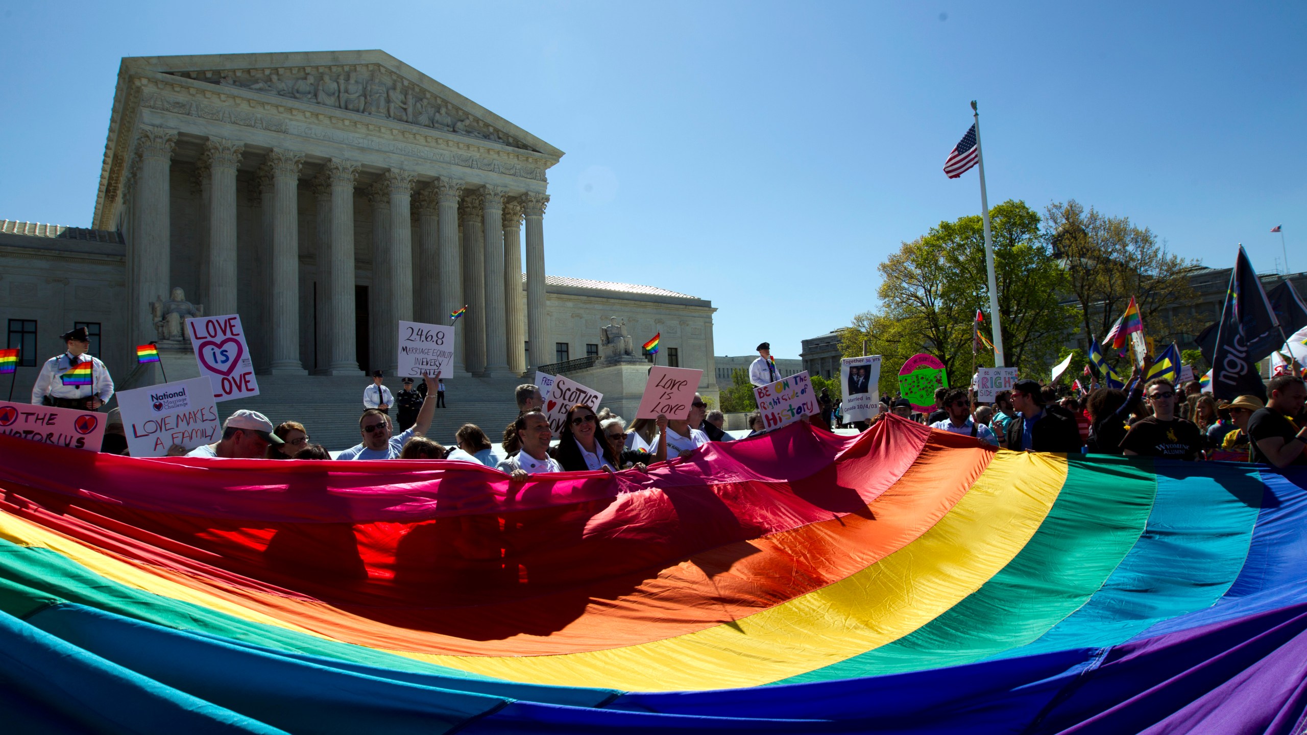 FILE - Demonstrators hold a rainbow pride flag outside the Supreme Court as justices deliberate Obergefell vs. Hodges, the case that legalized same-sex marriage nationwide, in Washington, April 28, 2015. (AP Photo/Jose Luis Magana, File)