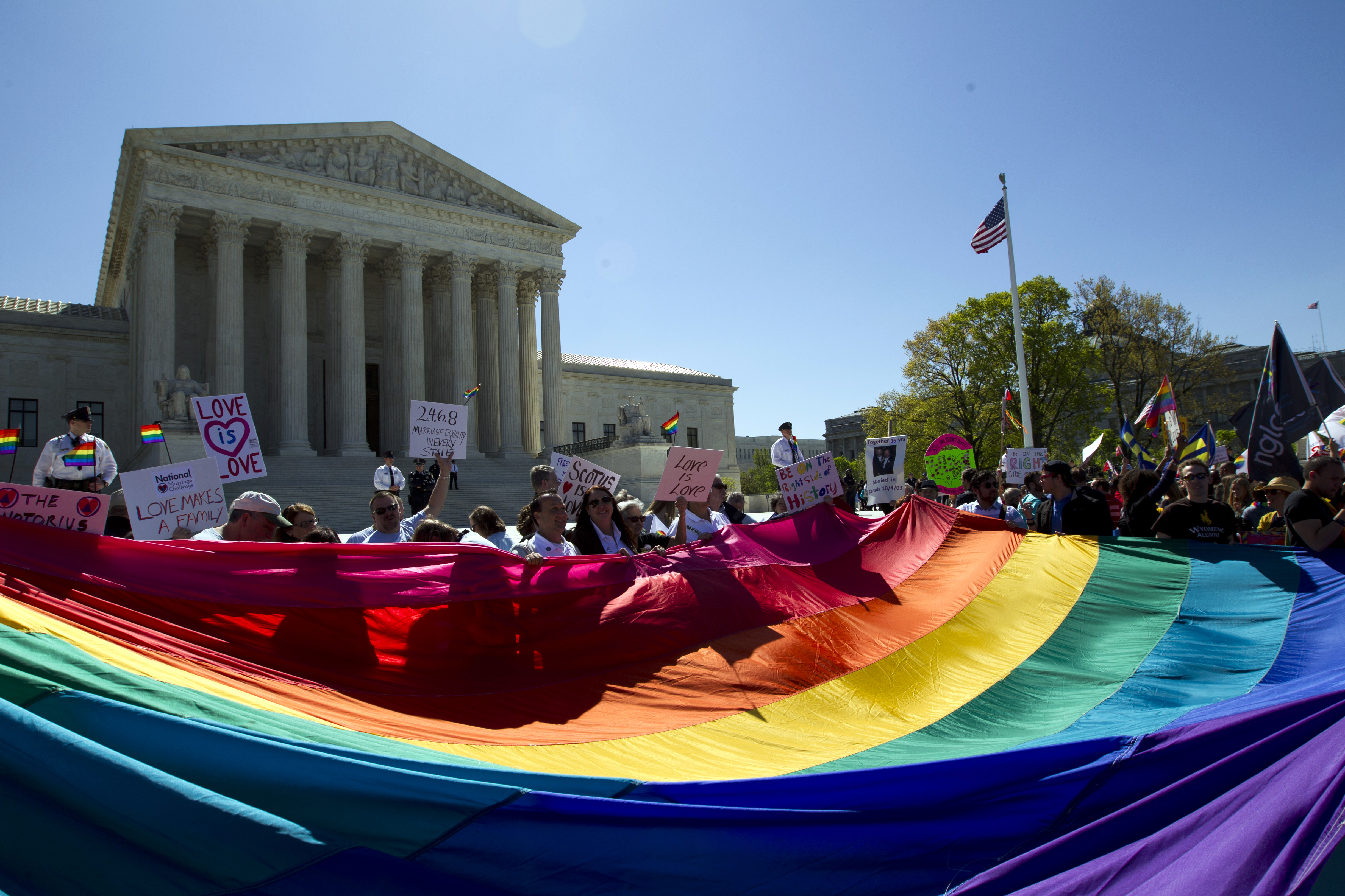 FILE - Demonstrators hold a rainbow pride flag outside the Supreme Court as justices deliberate Obergefell vs. Hodges, the case that legalized same-sex marriage nationwide, in Washington, April 28, 2015. (AP Photo/Jose Luis Magana, File)
