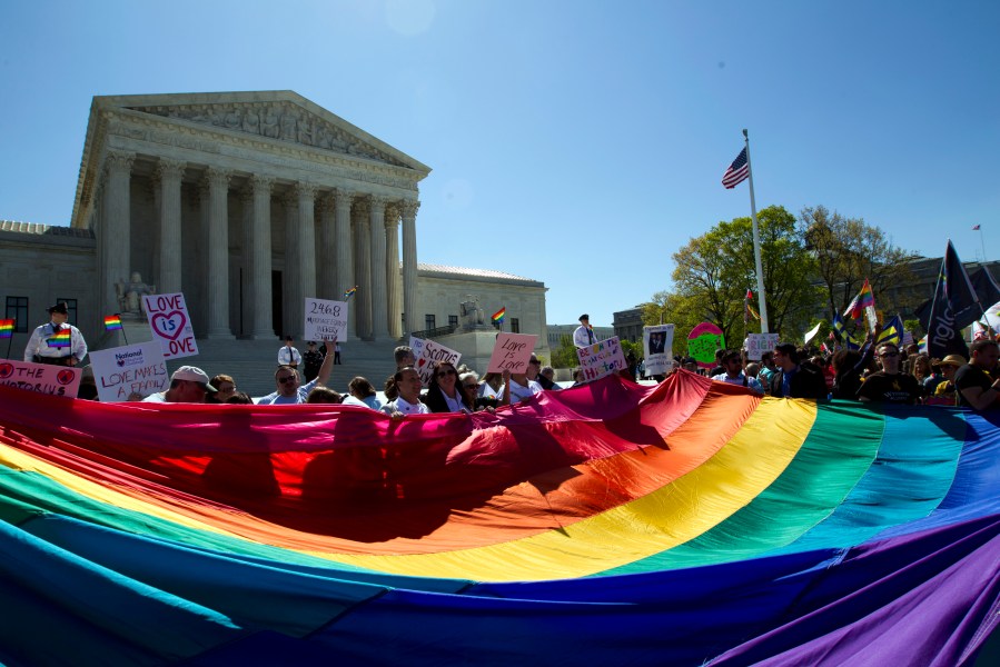 FILE - Demonstrators hold a rainbow pride flag outside the Supreme Court as justices deliberate Obergefell vs. Hodges, the case that legalized same-sex marriage nationwide, in Washington, April 28, 2015. (AP Photo/Jose Luis Magana, File)