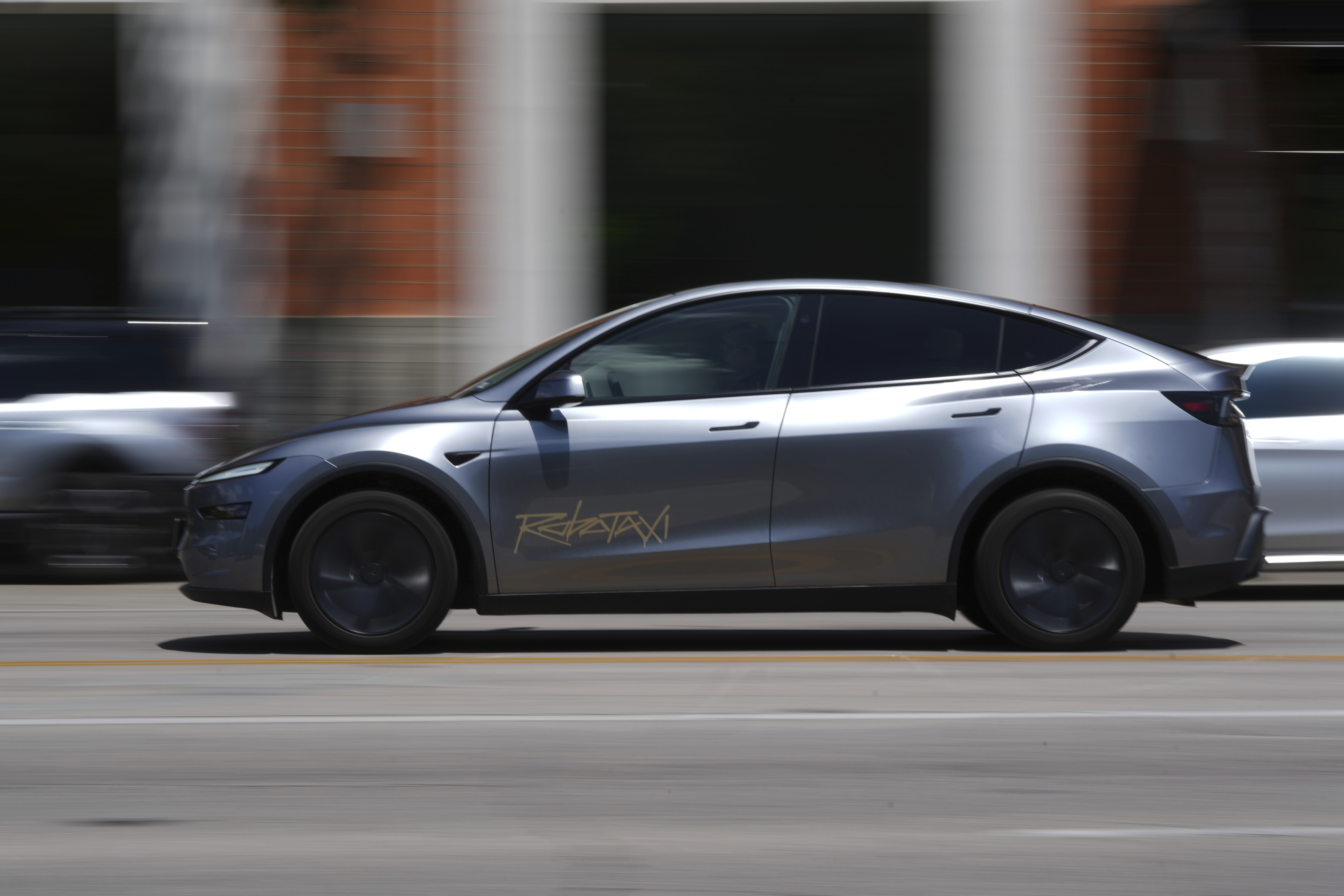 A driverless Tesla robotaxi, a ride-booking service, moves through traffic, Sunday, June 22, 2025, in Austin, Texas. (AP Photo/Eric Gay)