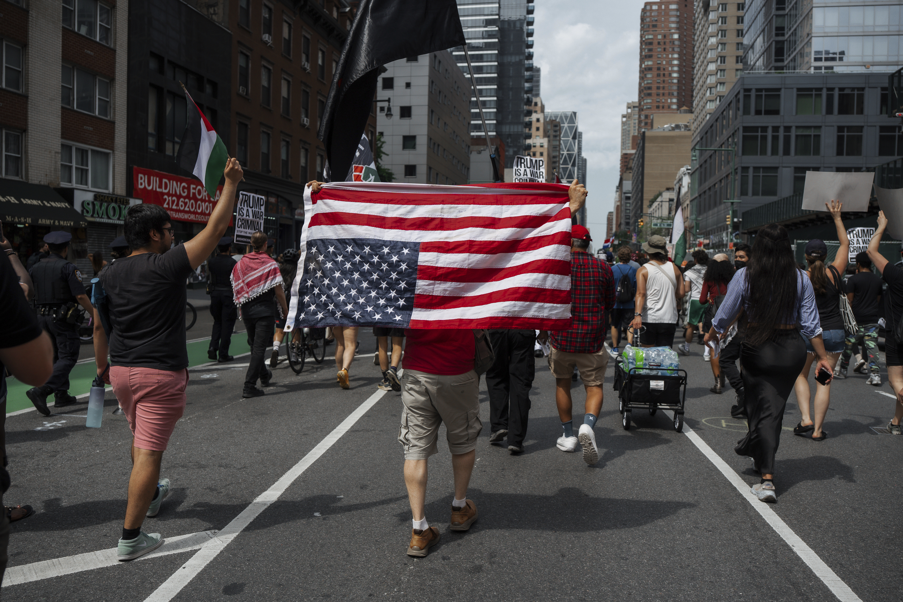 Protester carries an upside down American flag during a protest against U.S. strikes on Iran, Sunday, June 22, 2025, in New York. (AP Photo/Olga Fedorova)