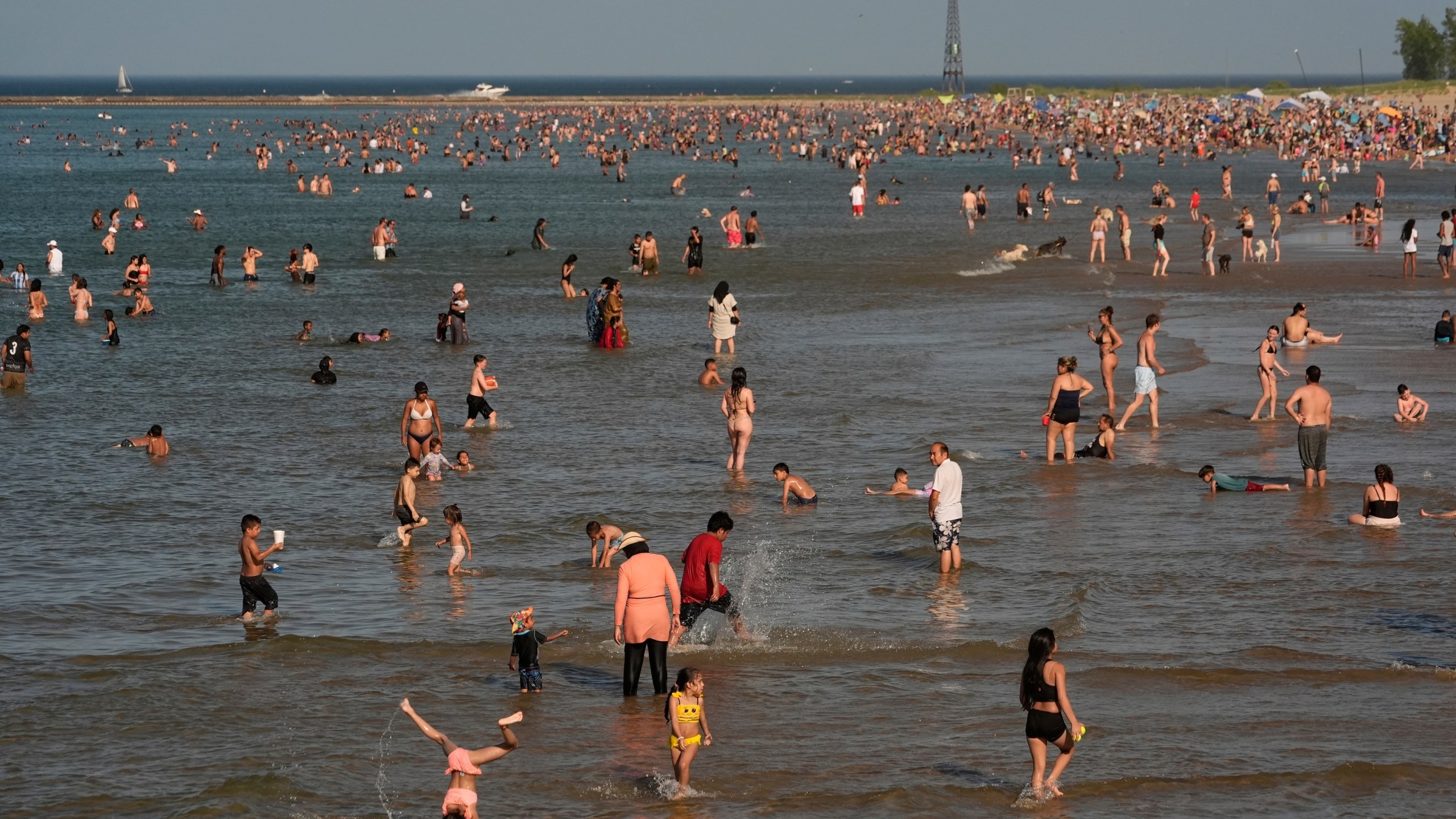 Beach goers crowd a public beach on the Lake Michigan shore, Sunday, June 22, 2025, in Chicago. (AP Photo/Kiichiro Sato)
