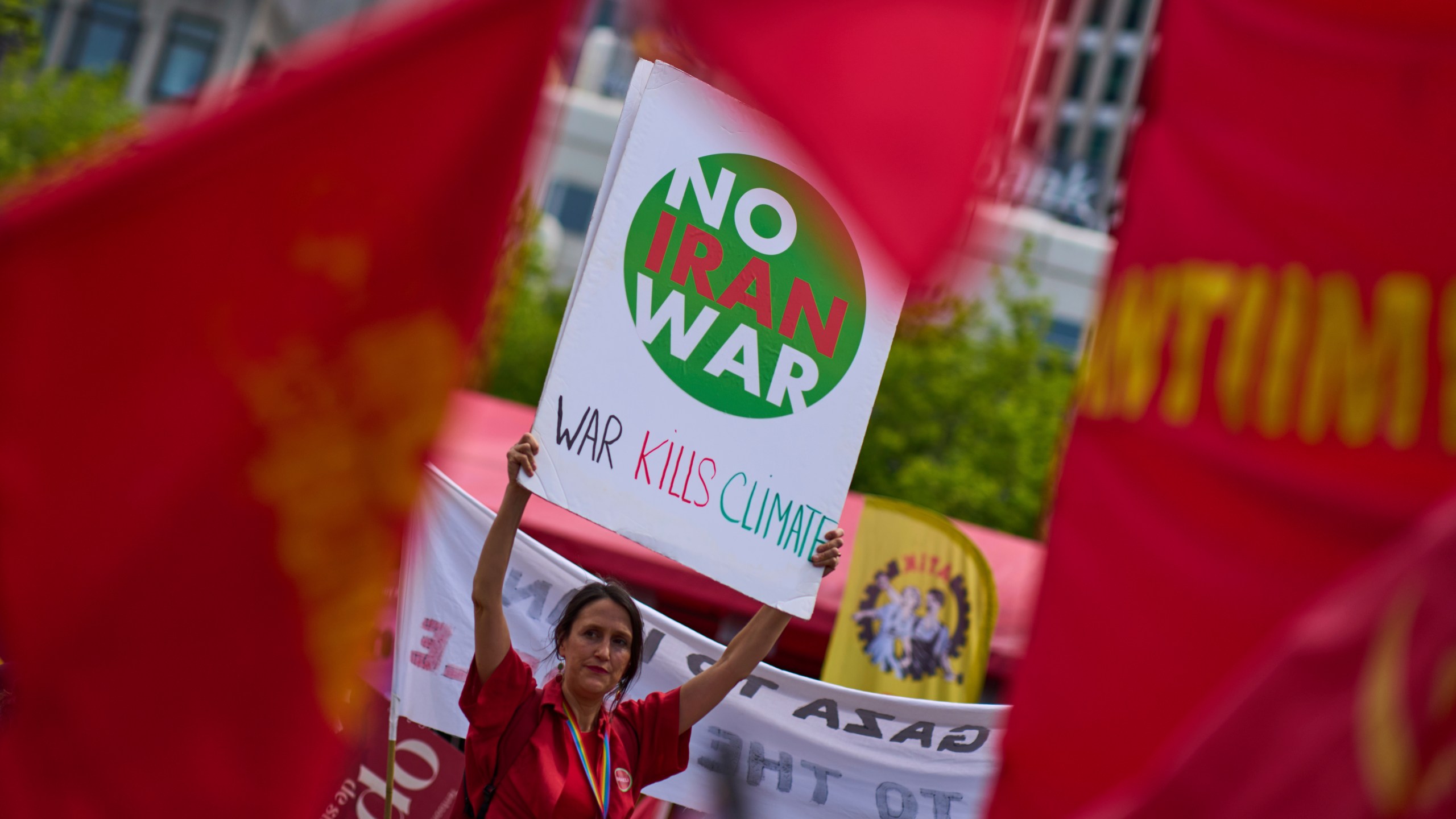 A woman holds a placard during a demonstration ahead of the NATO summit in The Hague, Netherlands, Sunday, June 22, 2025. (AP Photo/Peter Dejong)