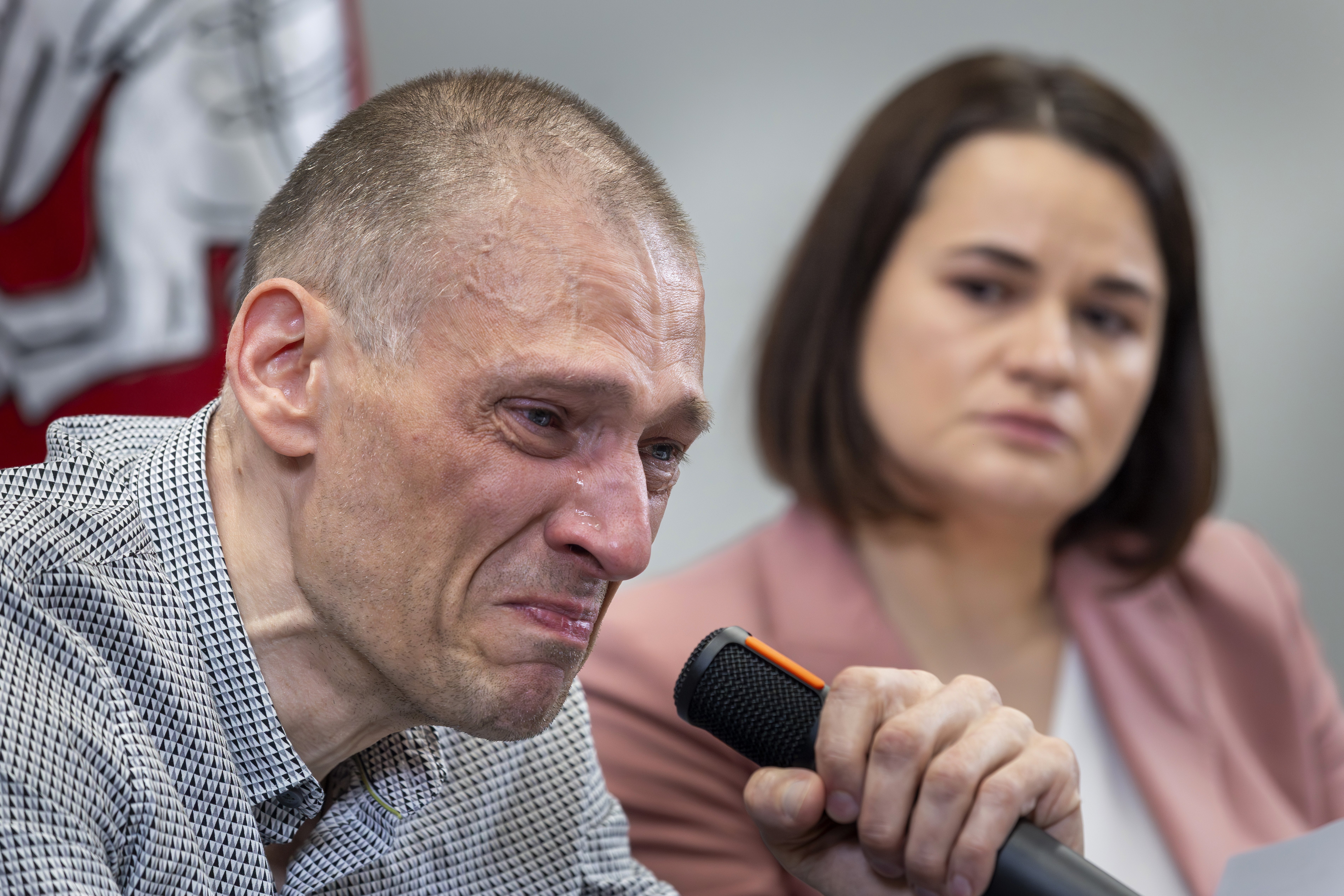 Syarhei Tsikhanouski, left, a Belarusian opposition activist released from a Belarusian prison, cries as his wife Belarusian opposition leader Sviatlana Tsikhanouskaya attends a news conference in Vilnius, Lithuania, Sunday, June 22, 2025. (AP Photo/Mindaugas Kulbis)