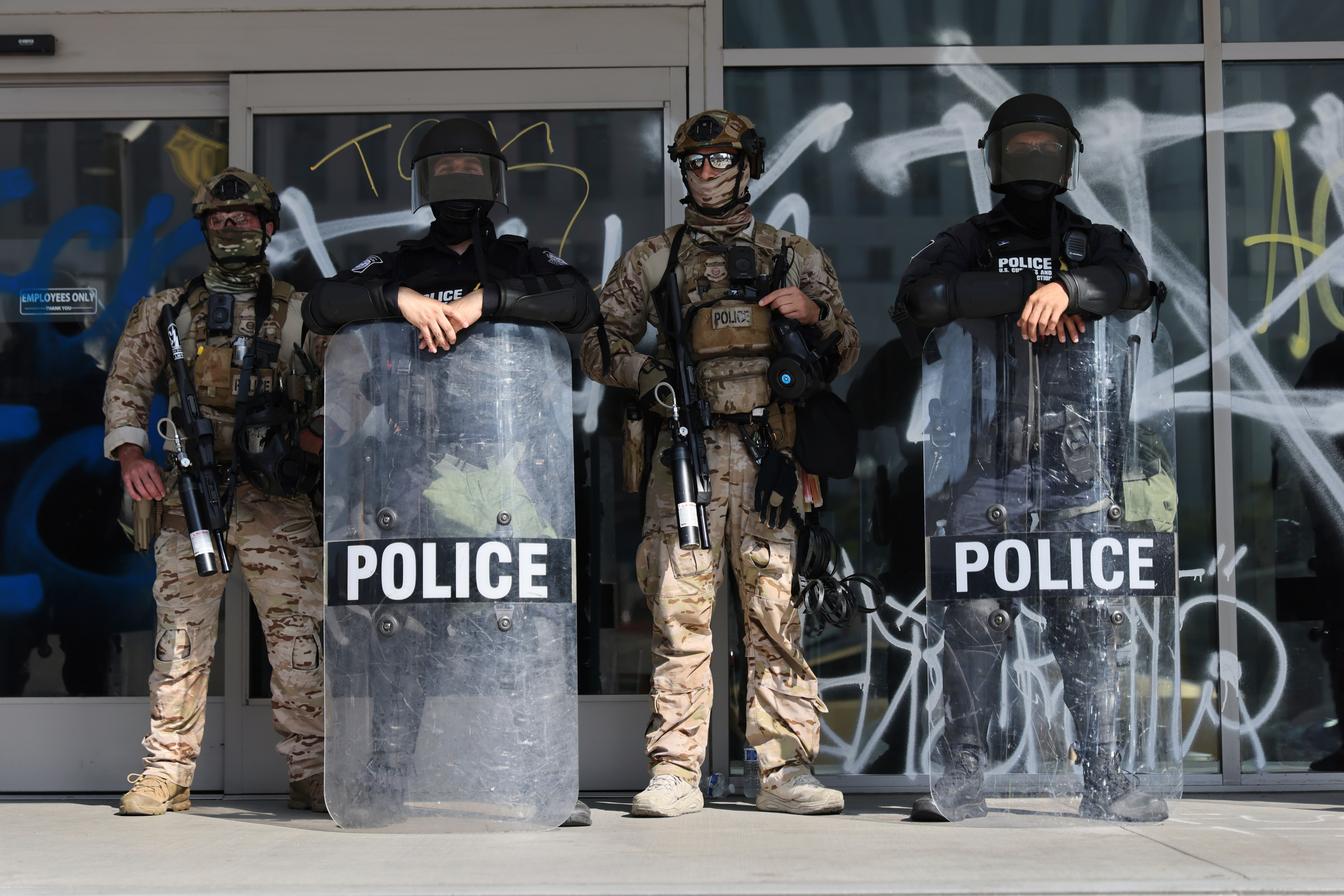 US Customs and Border Protection officers guard an entrance of the Federal Building in Los Angeles while protesters rally during a demonstration in response to a series of US Immigration and Customs Enforcement (ICE) raids throughout the country, on Tuesday, June 10th, 2025. (Gabrielle Lurie/San Francisco Chronicle via AP)