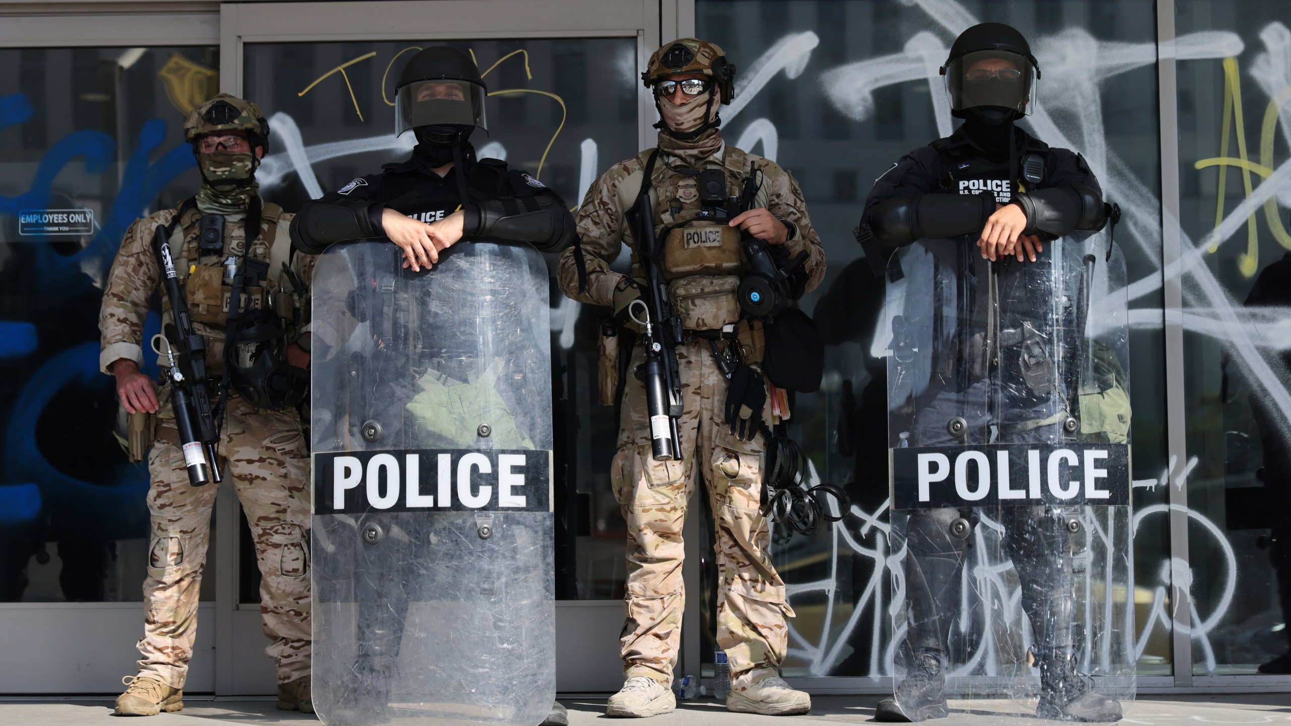 US Customs and Border Protection officers guard an entrance of the Federal Building in Los Angeles while protesters rally during a demonstration in response to a series of US Immigration and Customs Enforcement (ICE) raids throughout the country, on Tuesday, June 10th, 2025. (Gabrielle Lurie/San Francisco Chronicle via AP)
