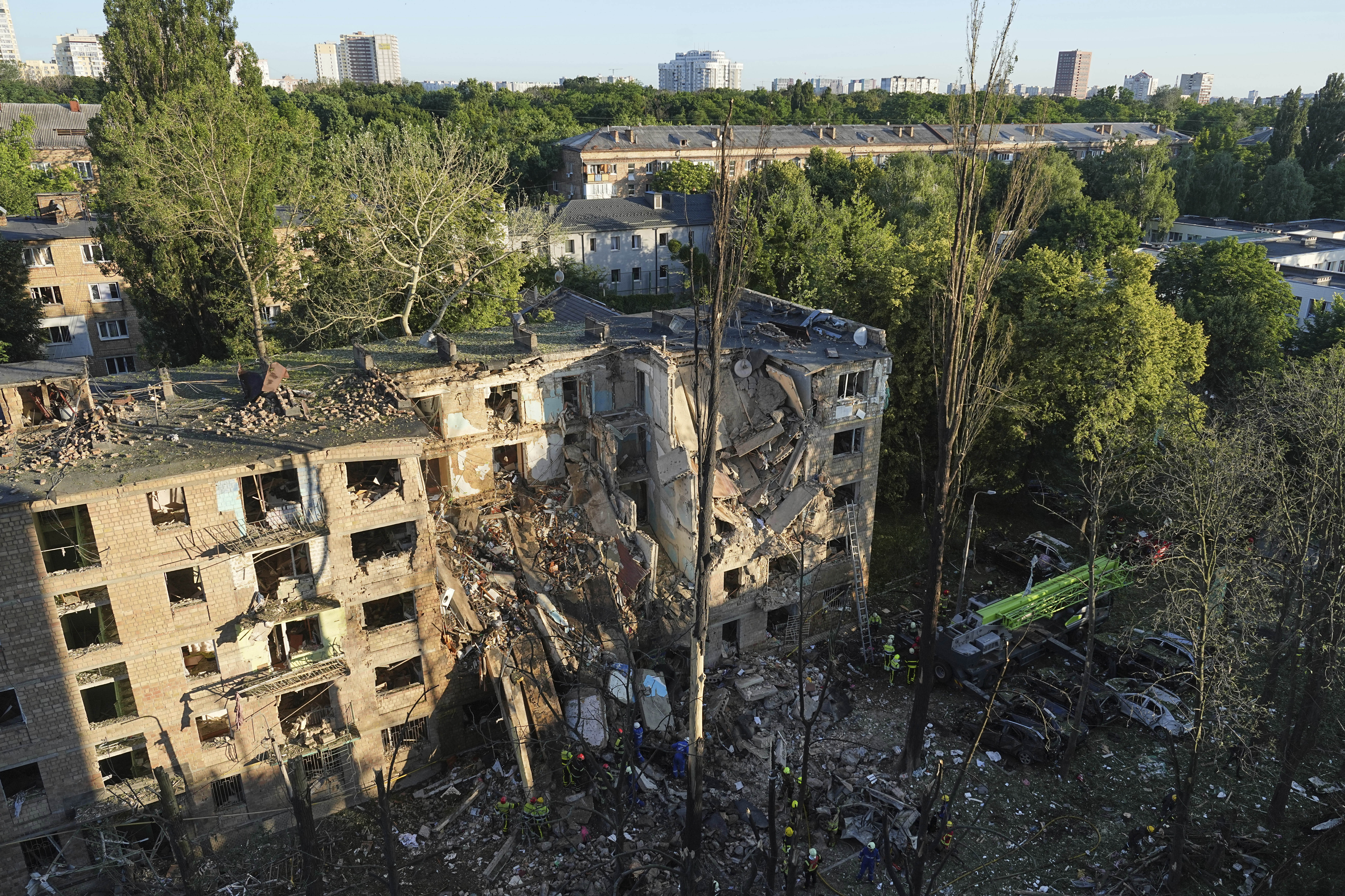 Firefighters work in a destroyed apartment building after a Russian attack in Kyiv, Ukraine, early Monday, June 23, 2025. (AP Photo/Efrem Lukatsky)