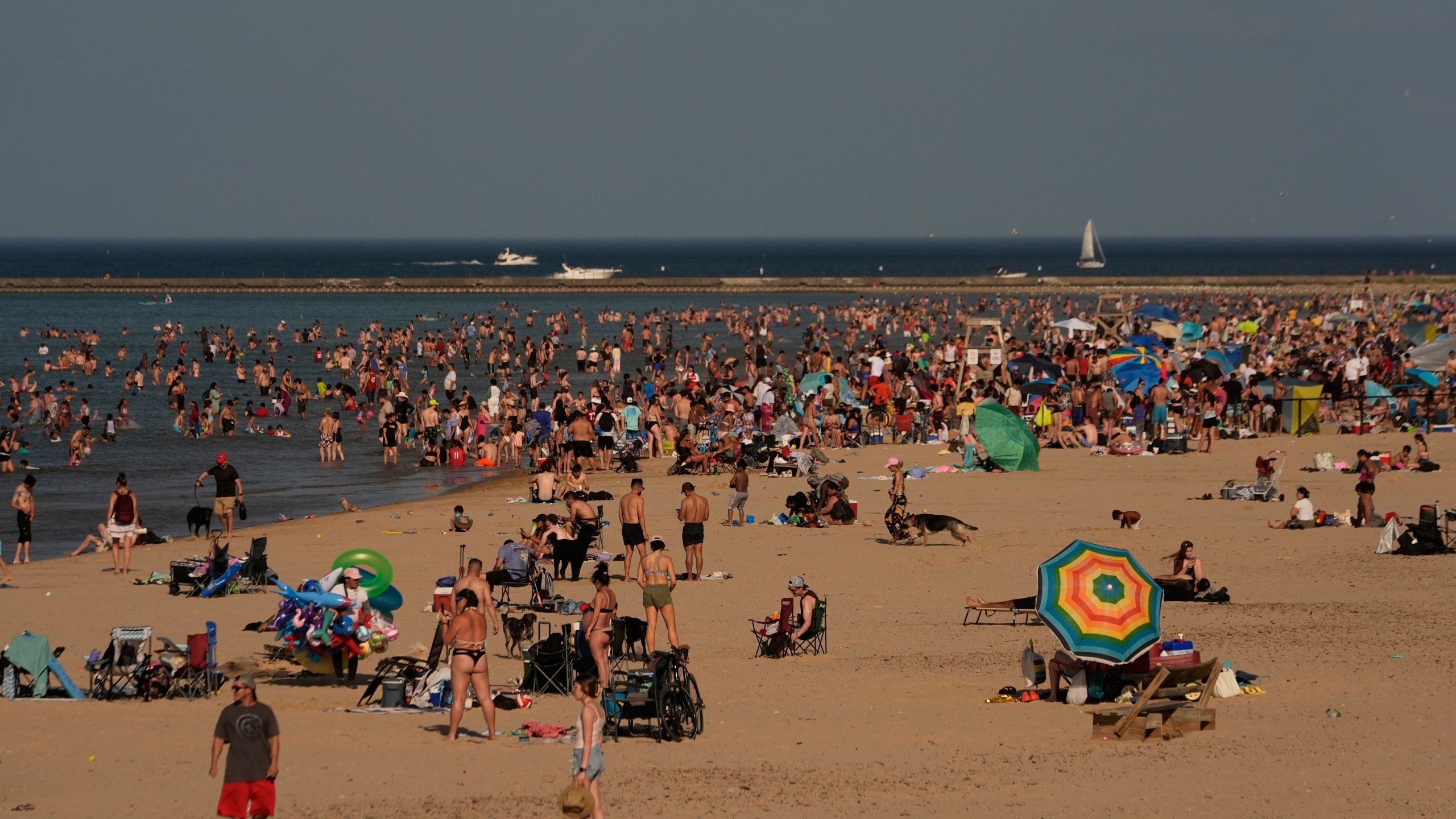 Beach goers crowd a public beach on the Lake Michigan shore, Sunday, June 22, 2025, in Chicago. (AP Photo/Kiichiro Sato)