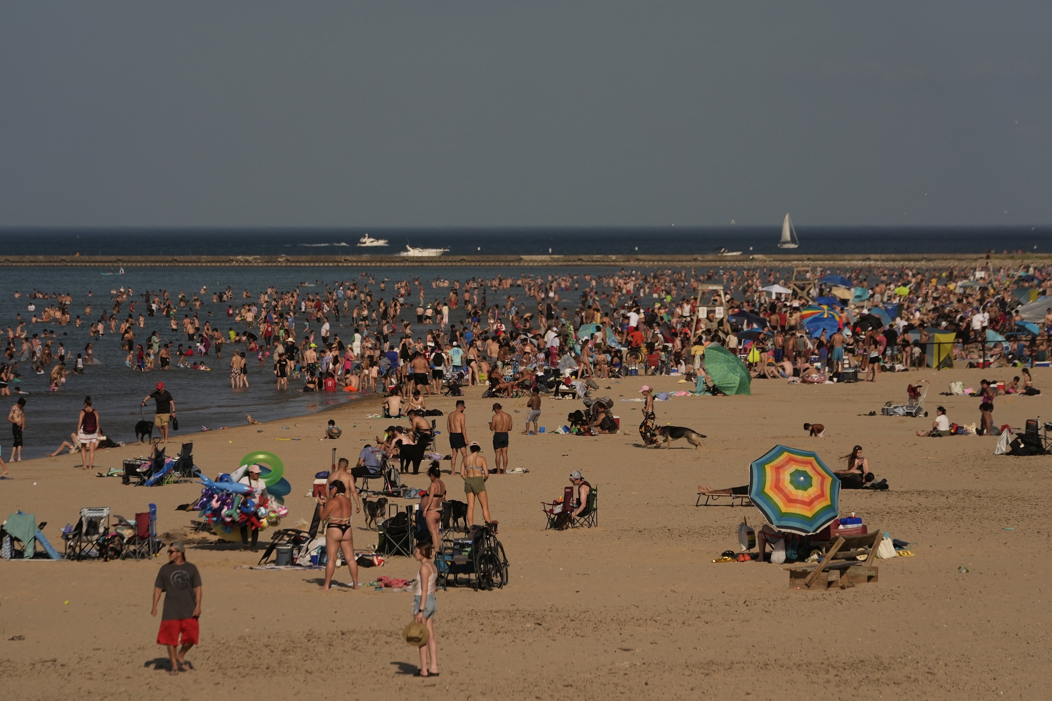 Beach goers crowd a public beach on the Lake Michigan shore, Sunday, June 22, 2025, in Chicago. (AP Photo/Kiichiro Sato)