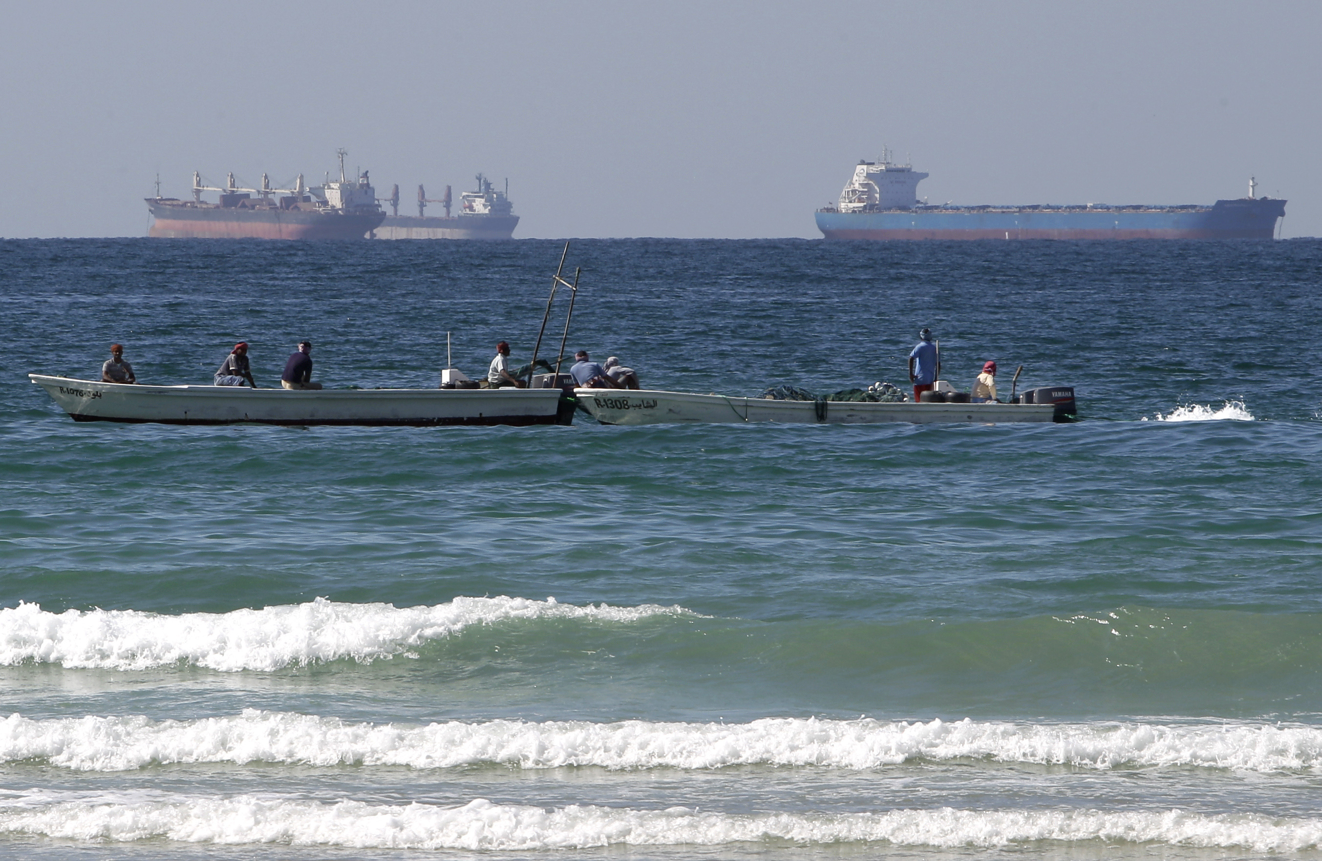 FILE - In this Jan. 19, 2012 file photo, fishing boats are seen in front of oil tankers south of the Strait of Hormuz, offshore the town of Ras Al Khaimah in United Arab Emirates. (AP Photo/Kamran Jebreili, File)