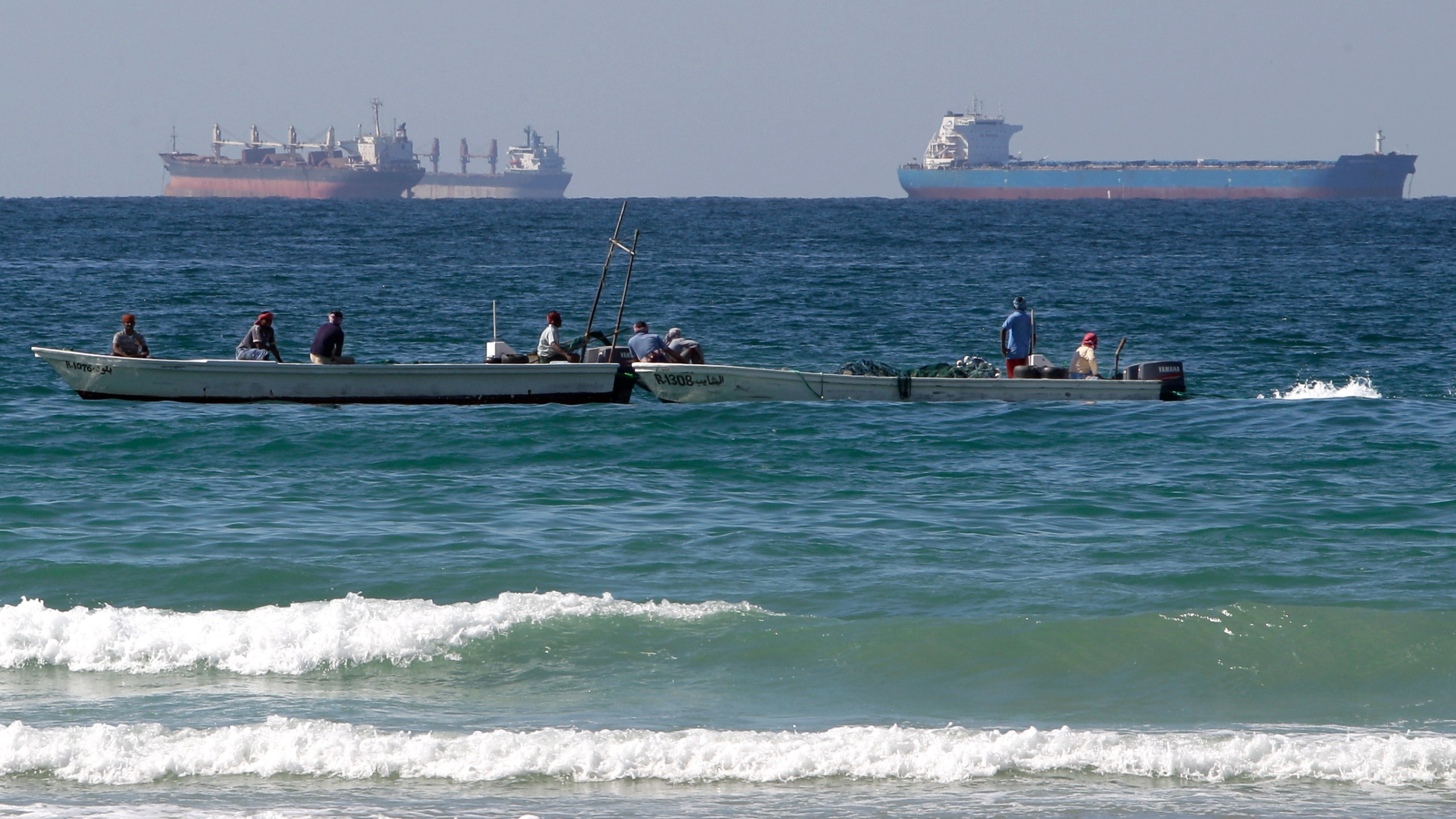 FILE - In this Jan. 19, 2012 file photo, fishing boats are seen in front of oil tankers south of the Strait of Hormuz, offshore the town of Ras Al Khaimah in United Arab Emirates. (AP Photo/Kamran Jebreili, File)