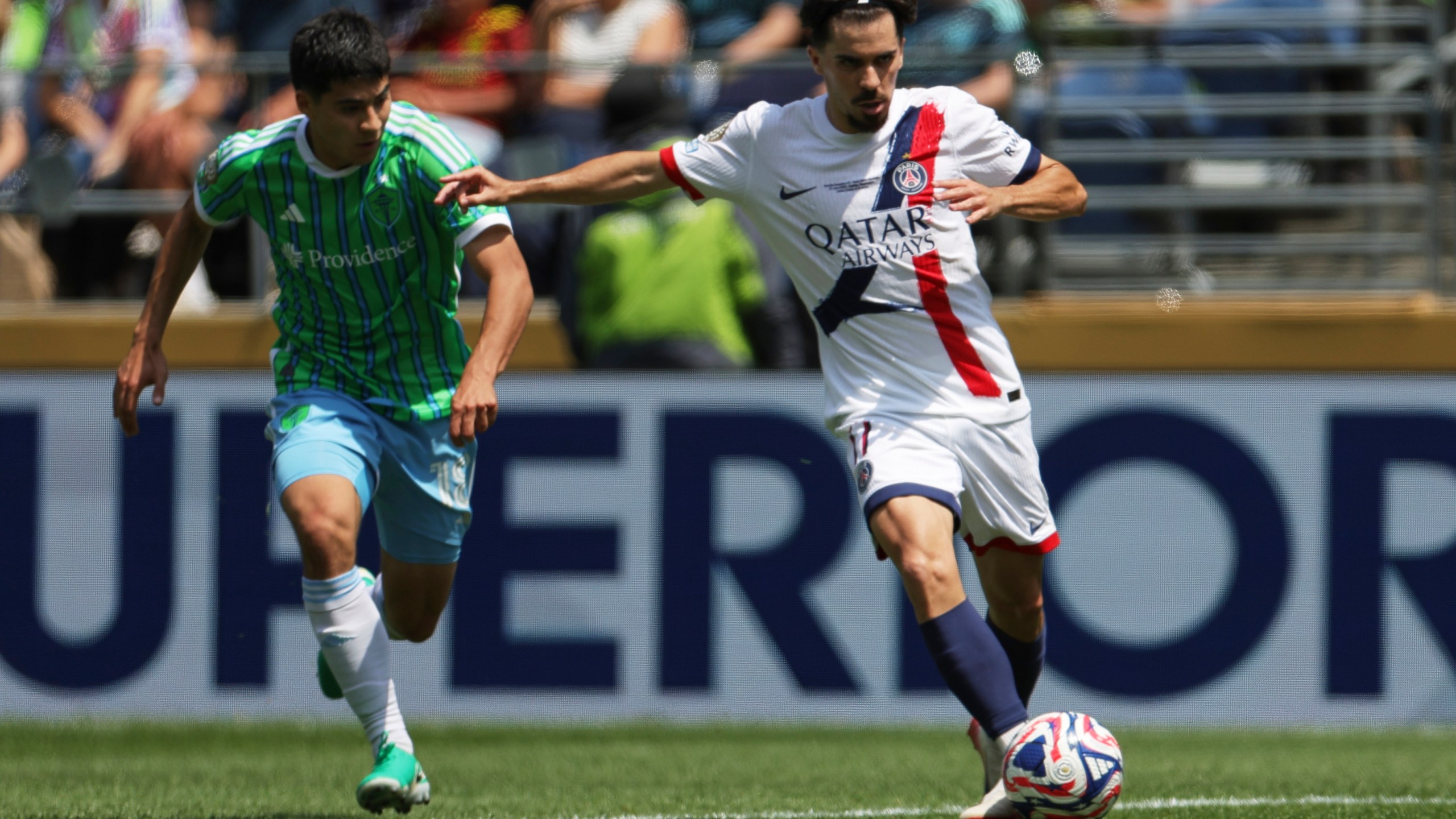 Paris Saint-Germain's Vitinha, right, passes the ball as Seattle Sounders' Obed Vargas looks on during the Club World Cup Group B soccer match between Seattle Sounders and PSG in Seattle, Monday, June 23, 2025. (AP Photo/Ryan Sun)