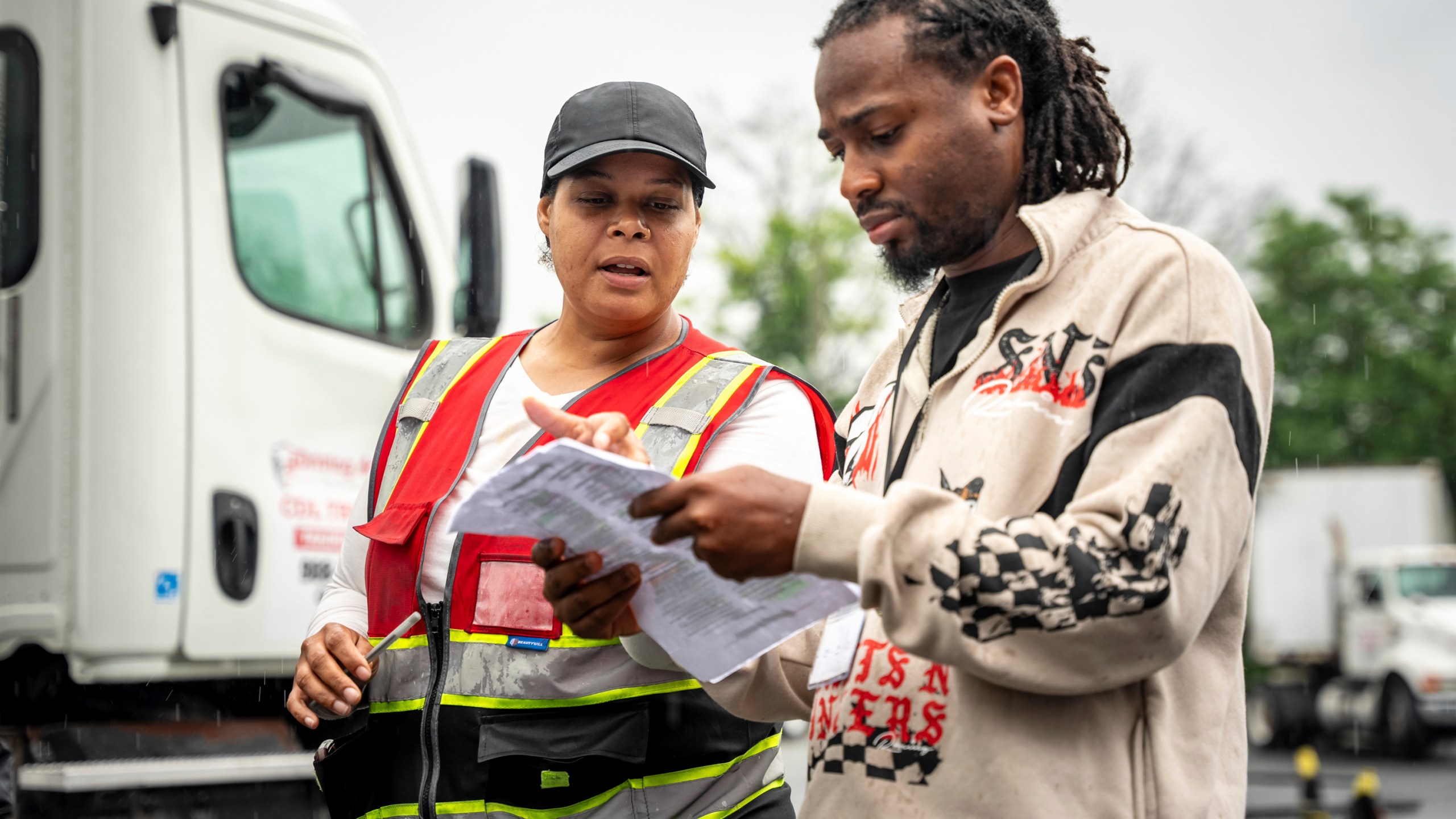 An instructor helps a student study at the Driving Academy on Tuesday, June 10, 2025 in Linden, N.J. where students prepare to obtain a Commercial Driver’s License (CDL) with multilingual instructors. (AP Photo/Angelina Katsanis)