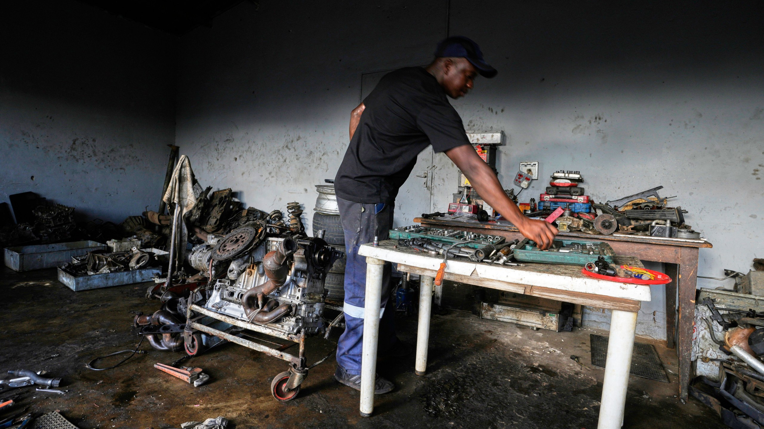 Themba Maseko, a 39-year-old mechanic, works inside his workshop in Brakpan, east of Johannesburg, South Africa, Wednesday, April 30, 2025. (AP Photo/Themba Hadebe)