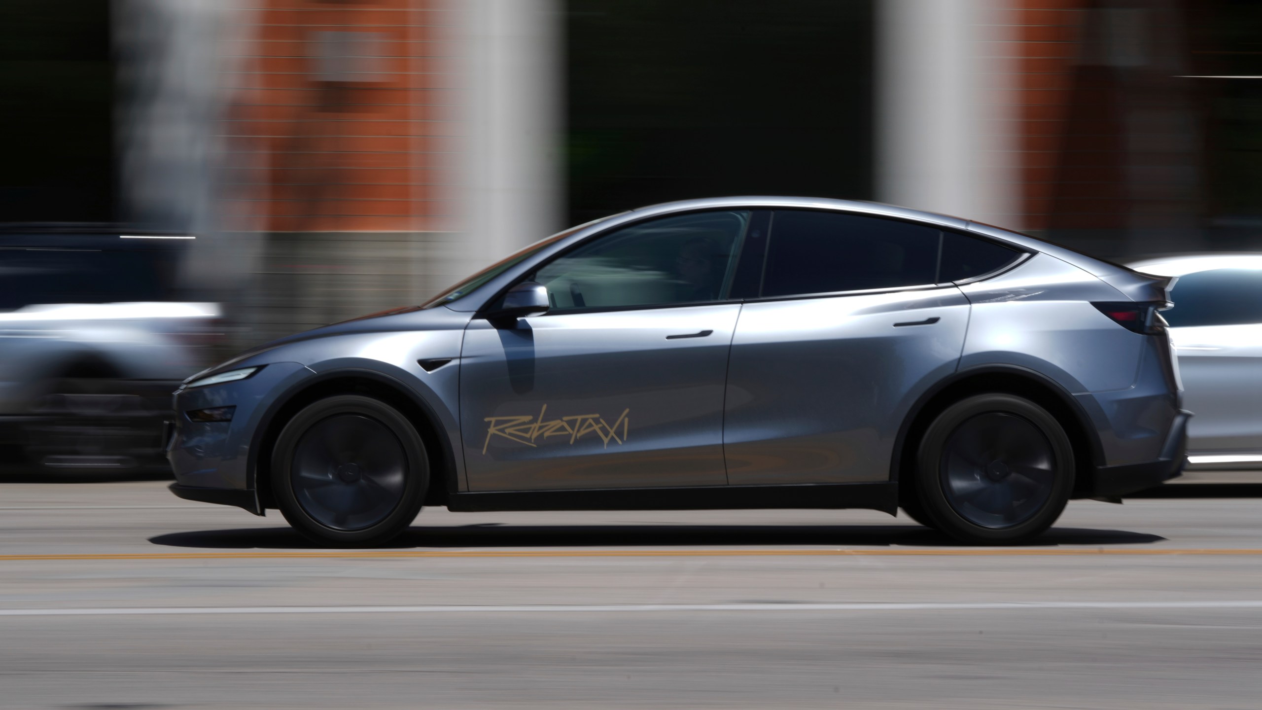 A driverless Tesla robotaxi, a ride-booking service, moves through traffic, Sunday, June 22, 2025, in Austin, Texas. (AP Photo/Eric Gay)