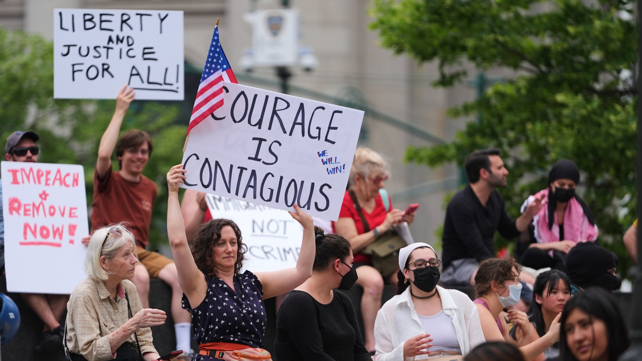 Demonstrators hold signs during a protest against deportation by Immigration and Customs Enforcement Thursday, June 12, 2025, in New York. (AP Photo/Frank Franklin II)
