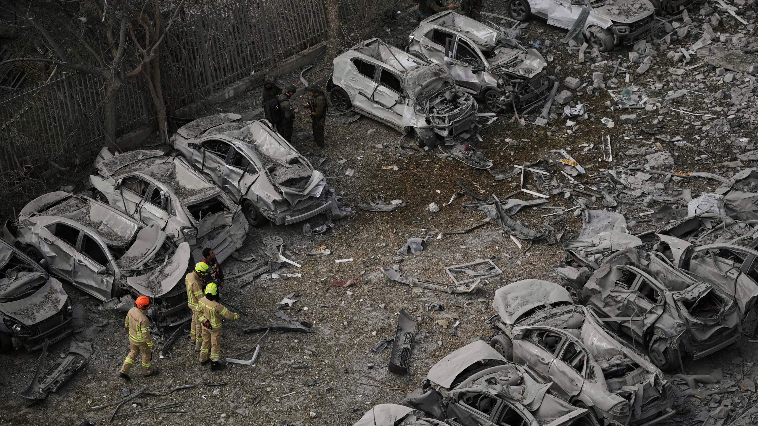 Firefighters inspect the site struck by an Iranian missile strike that killed several people, in Beersheba, Israel, on Tuesday, June 24, 2025. (AP Photo/Leo Correa)