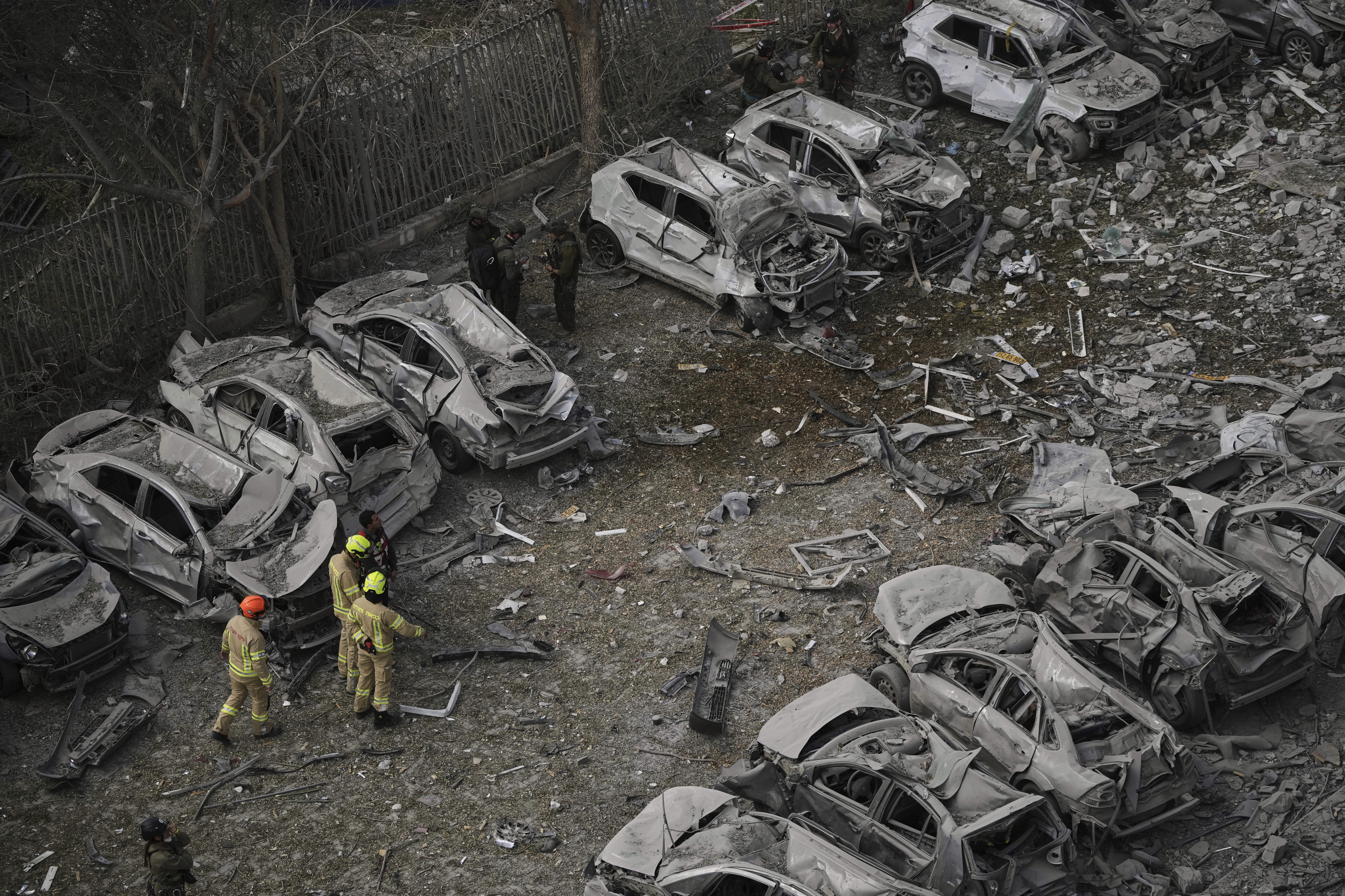 Firefighters inspect the site struck by an Iranian missile strike that killed several people, in Beersheba, Israel, on Tuesday, June 24, 2025. (AP Photo/Leo Correa)