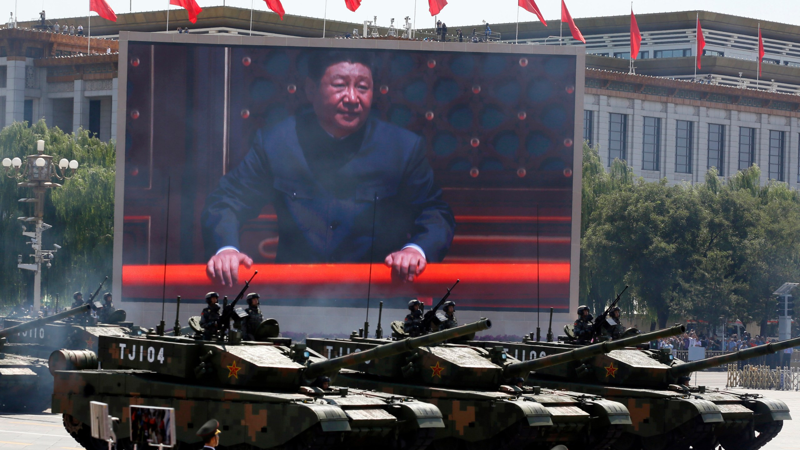 FILE - Chinese President Xi Jinping is displayed on a screen as Type 99A2 Chinese battle tanks take part in a parade commemorating the 70th anniversary of Japan's surrender during World War II held in front of Tiananmen Gate in Beijing on Sept. 3, 2015. (AP Photo/Ng Han Guan, File)