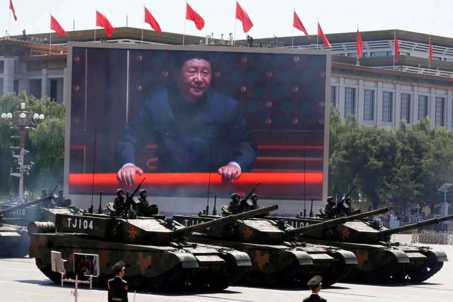 FILE - Chinese President Xi Jinping is displayed on a screen as Type 99A2 Chinese battle tanks take part in a parade commemorating the 70th anniversary of Japan's surrender during World War II held in front of Tiananmen Gate in Beijing on Sept. 3, 2015. (AP Photo/Ng Han Guan, File)